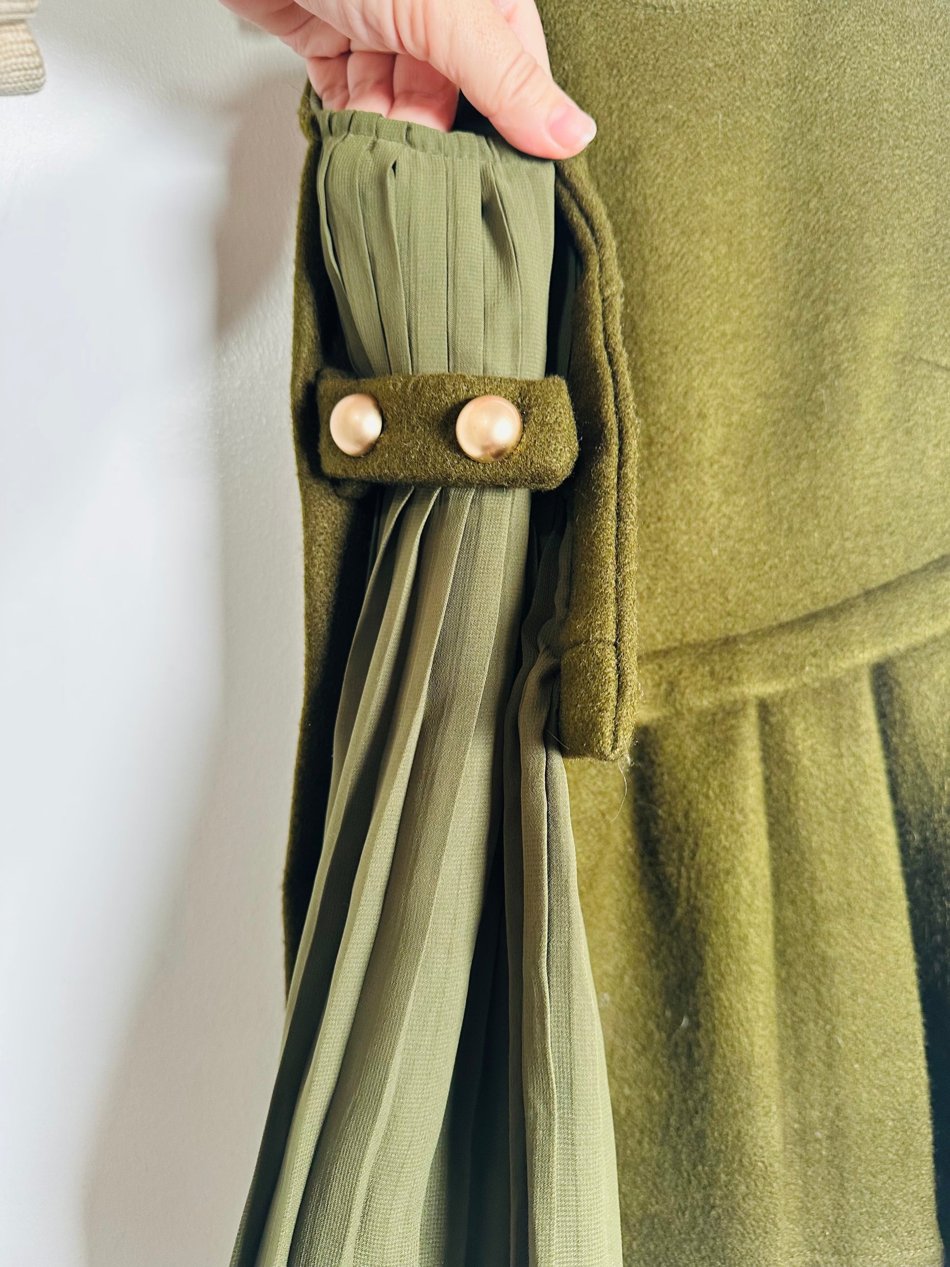 Close-up of a green fabric with buttons on a plain background