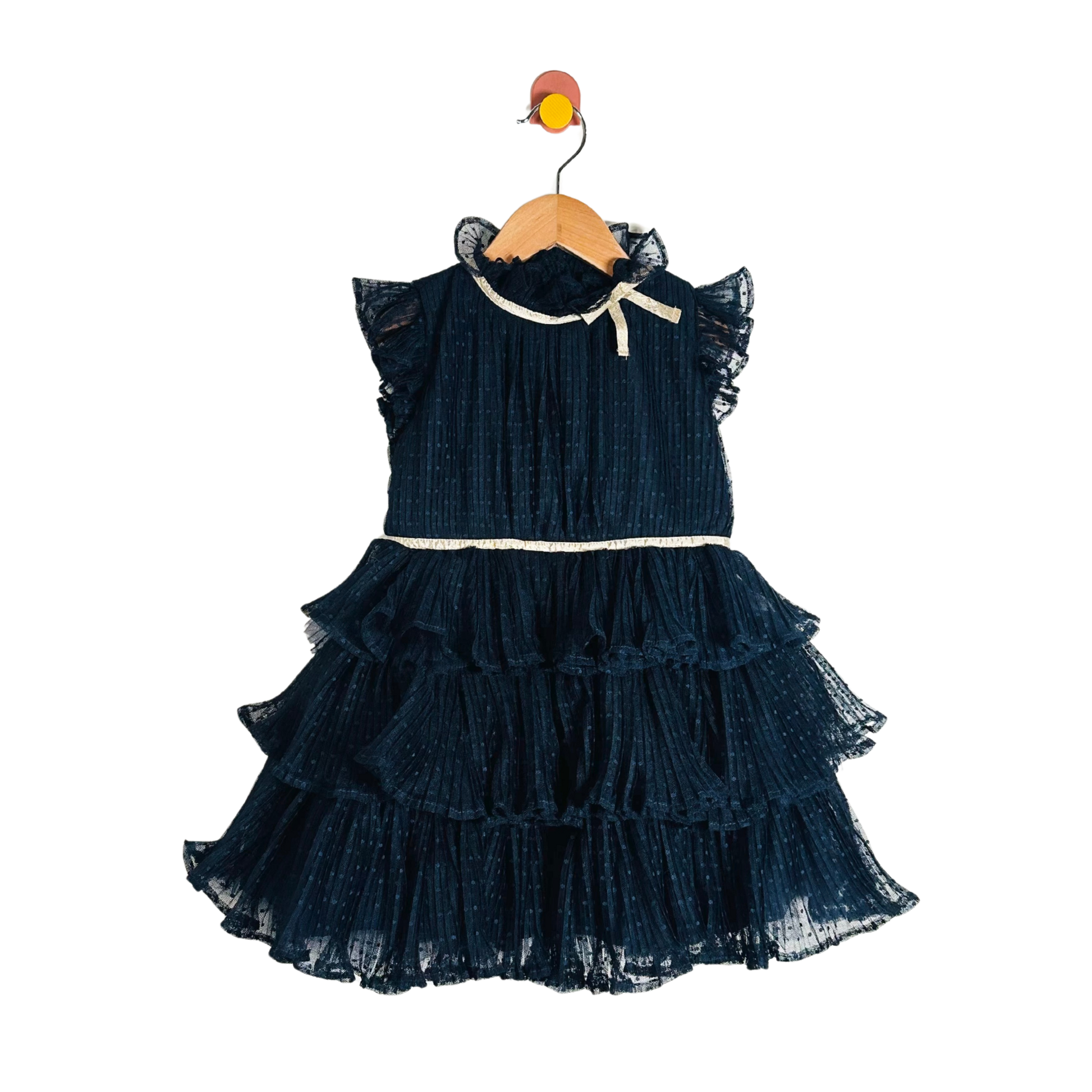 Navy blue ruffled dress on a wooden hanger against a white background