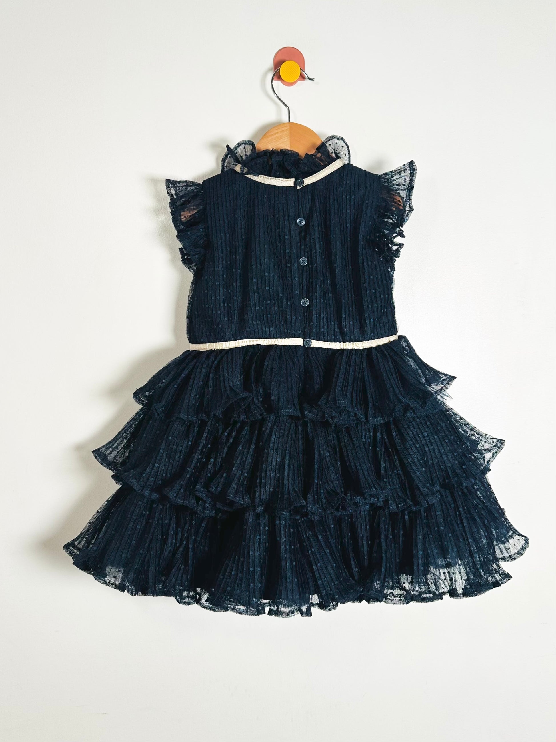Navy blue dress with ruffled layers on a white background