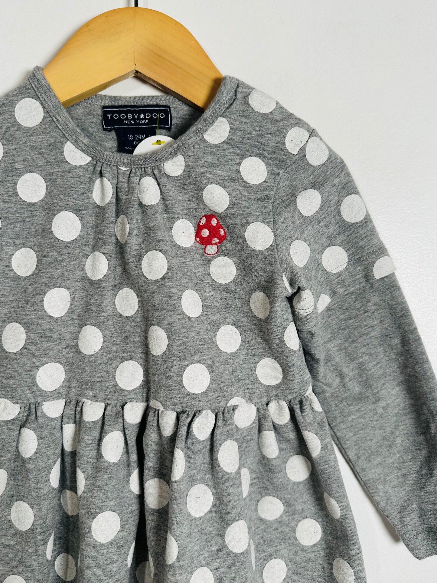 Gray dress with white polka dots and a red mushroom design on a hanger.