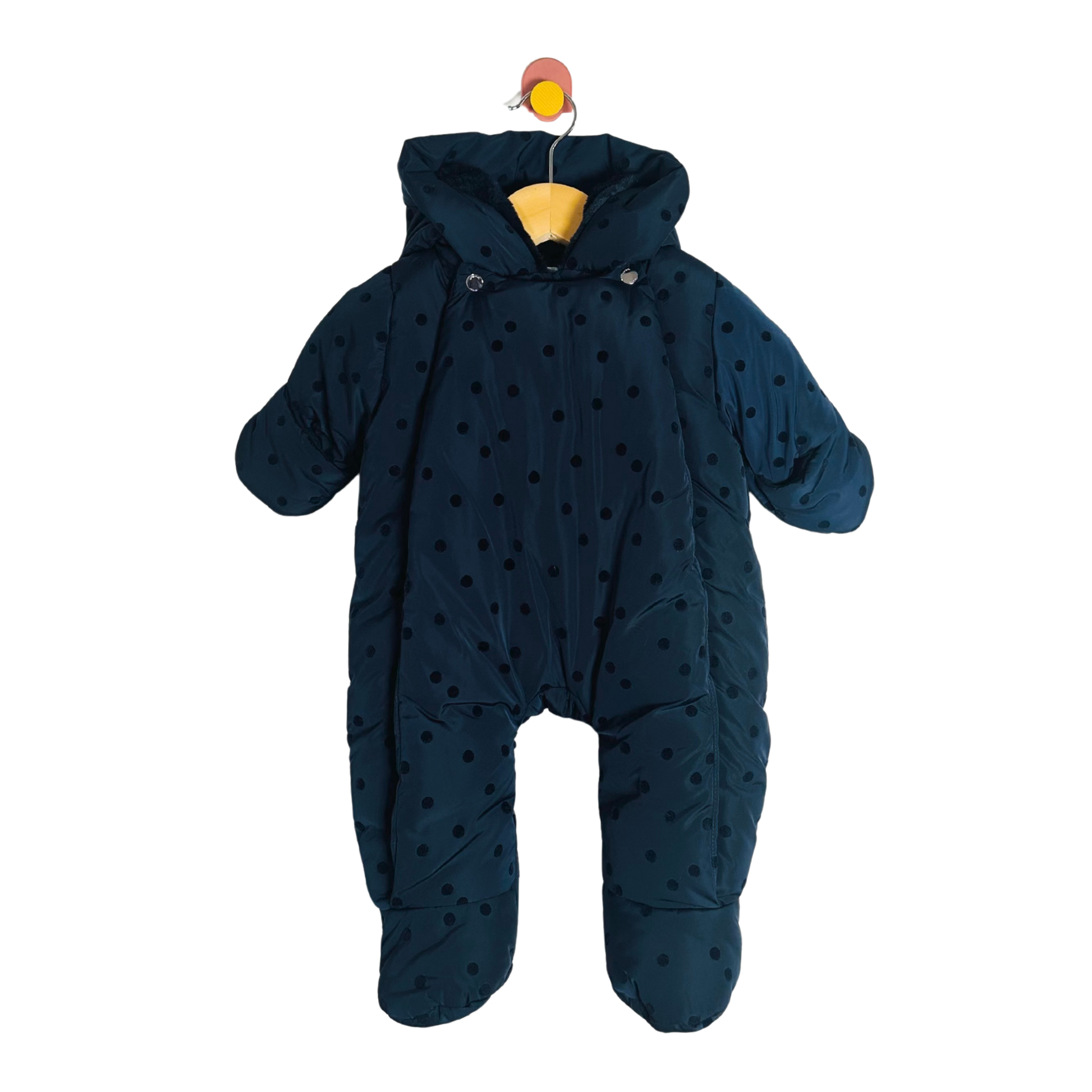 Navy blue baby snowsuit with polka dots on a white background