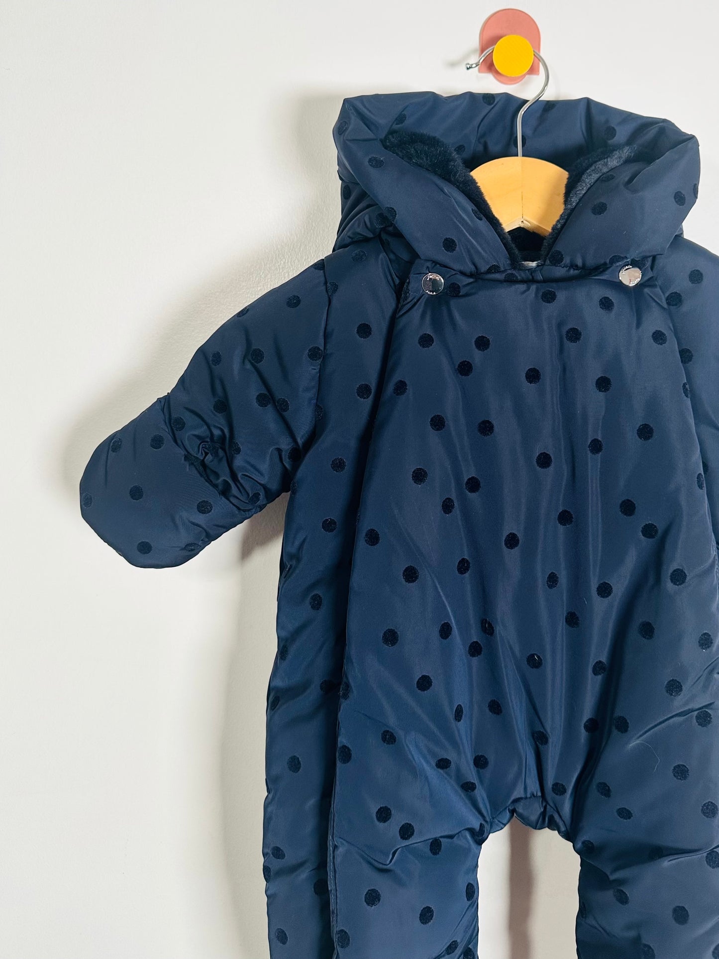 Blue snowsuit with polka dots on a white background