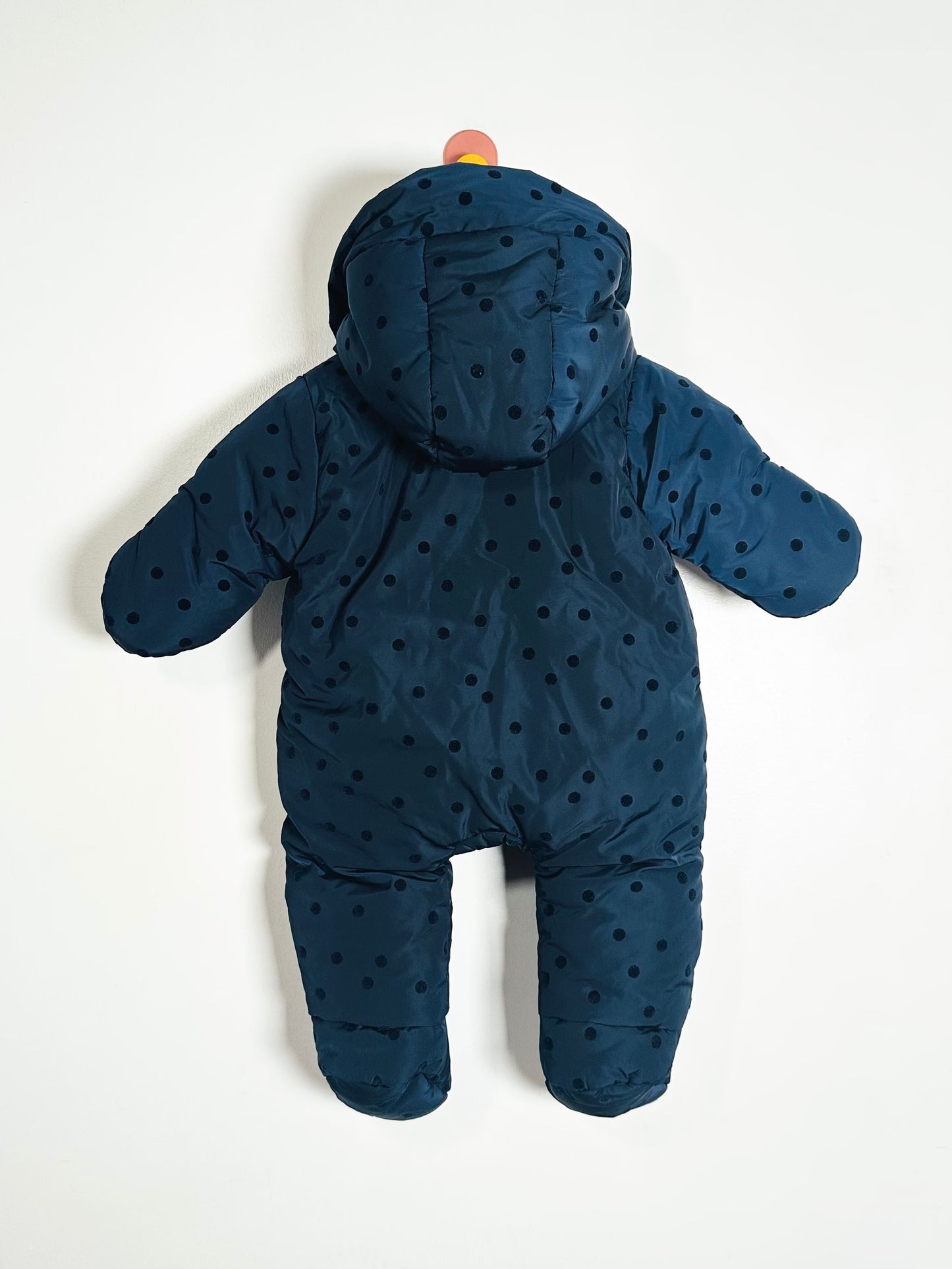 Blue baby snowsuit with polka dots on a white background