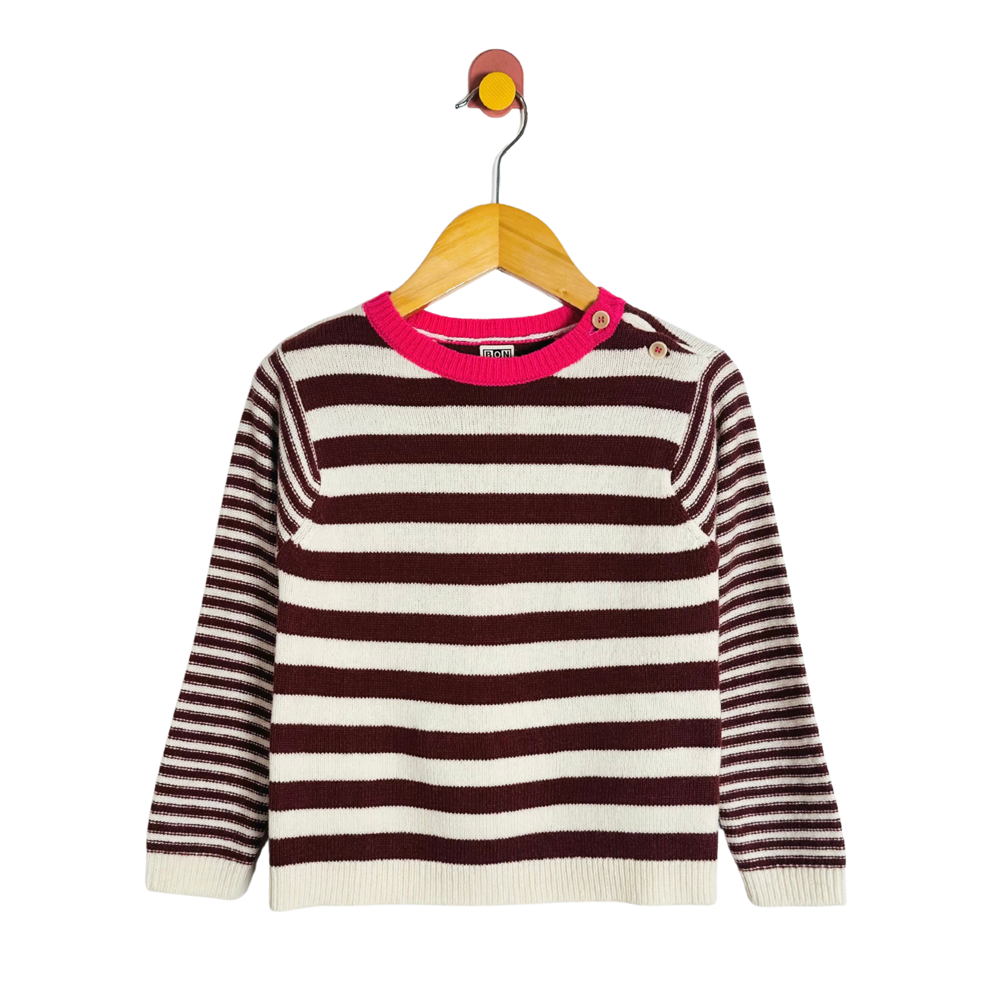 Striped sweater with pink neckline on a hanger against a white background