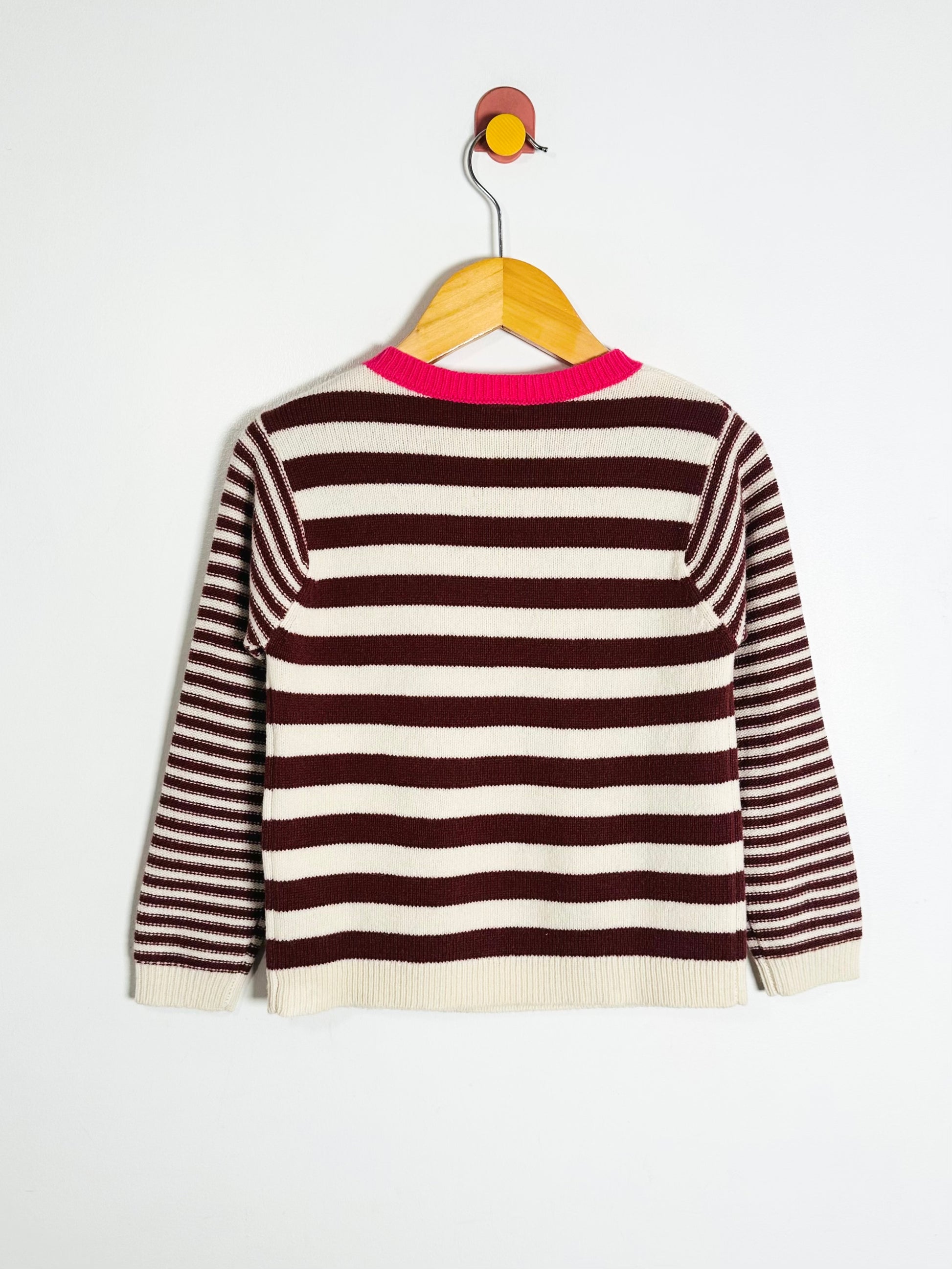 Striped sweater on a hanger against a white background
