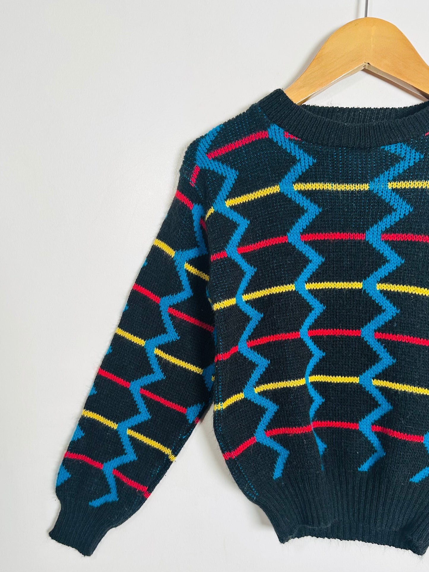 sweater with colorful zigzag pattern on a white background