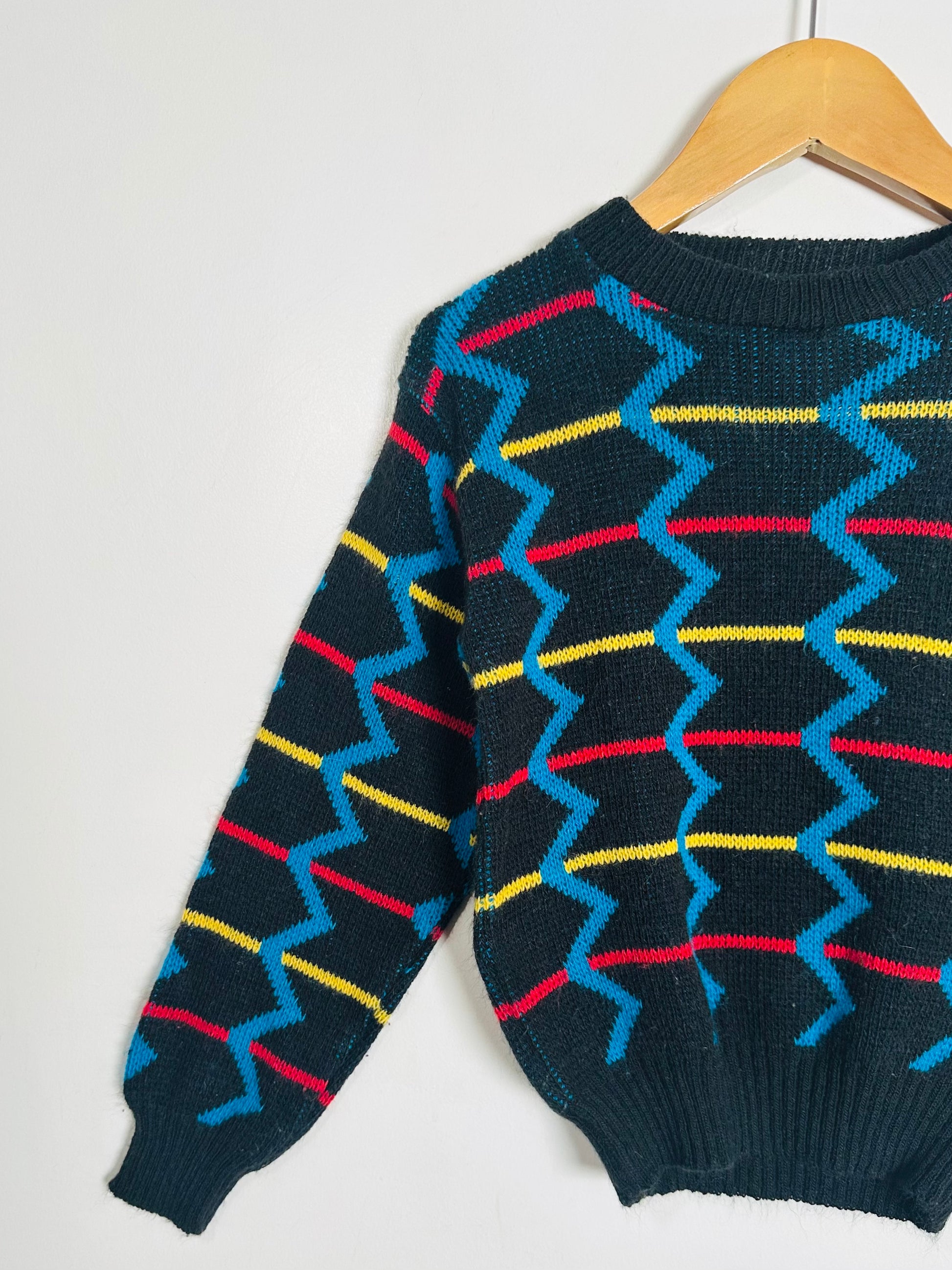sweater with colorful zigzag pattern on a white background