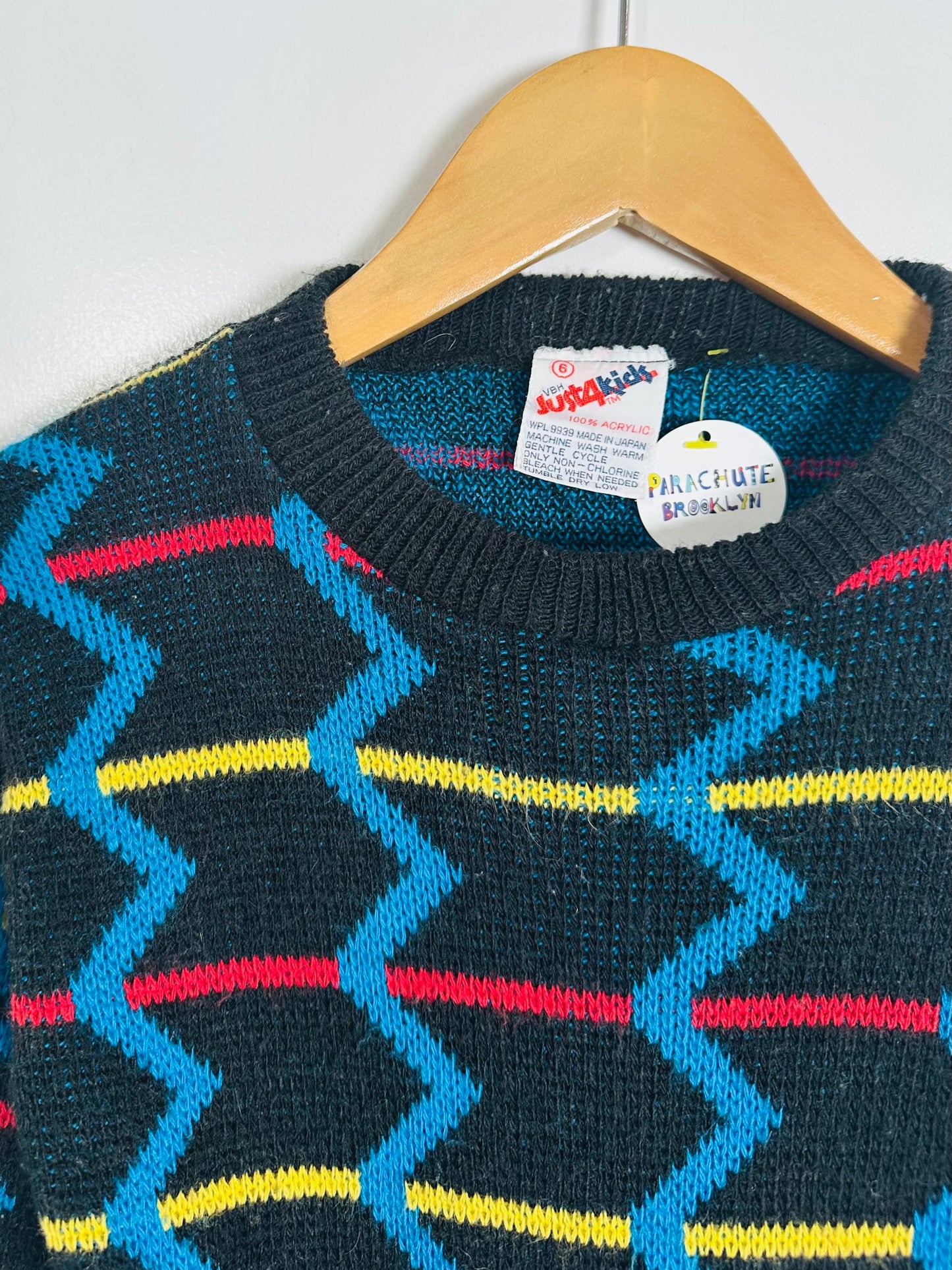 Children's sweater with colorful pattern on a hanger