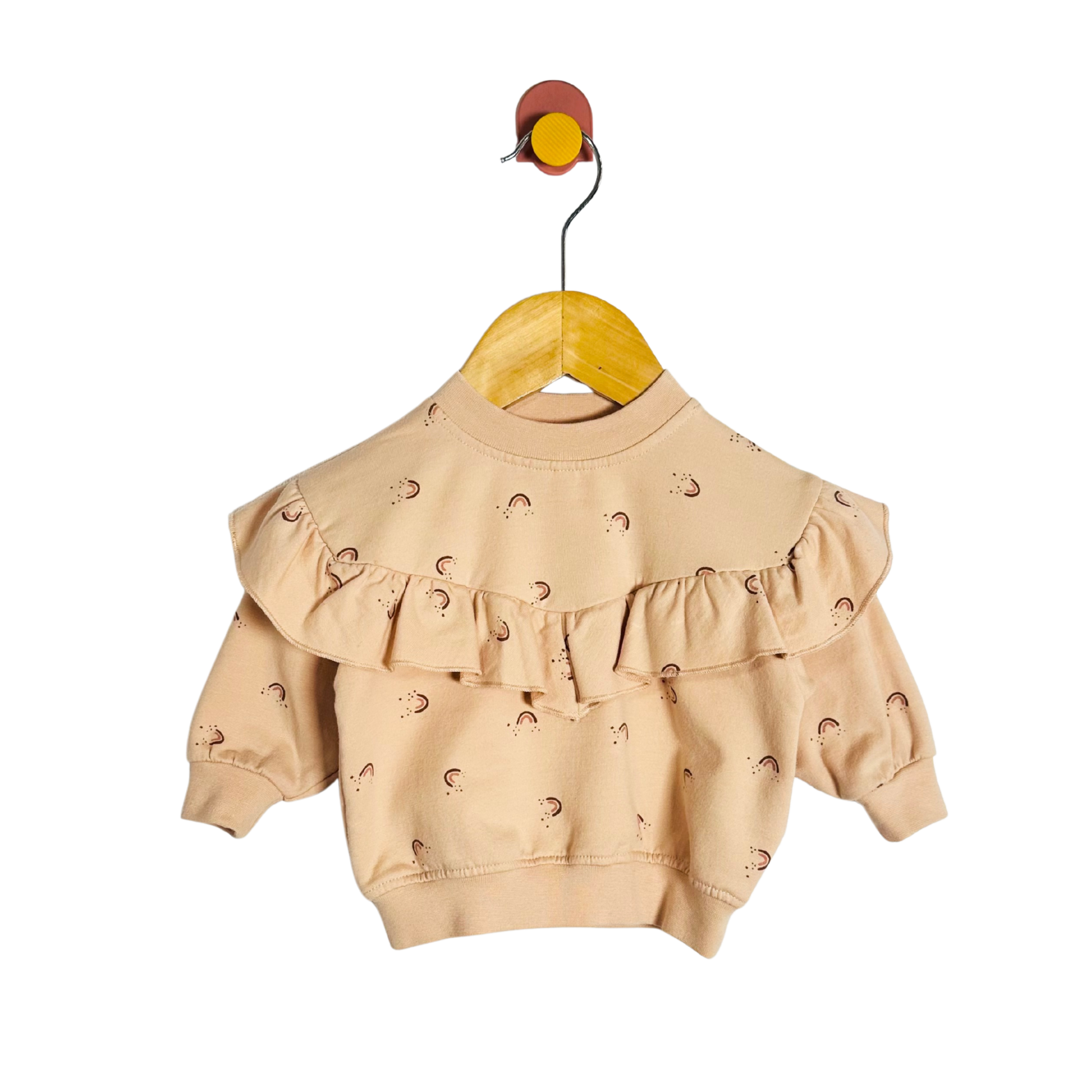 Beige baby sweater with ruffled details on a yellow hanger against a white background