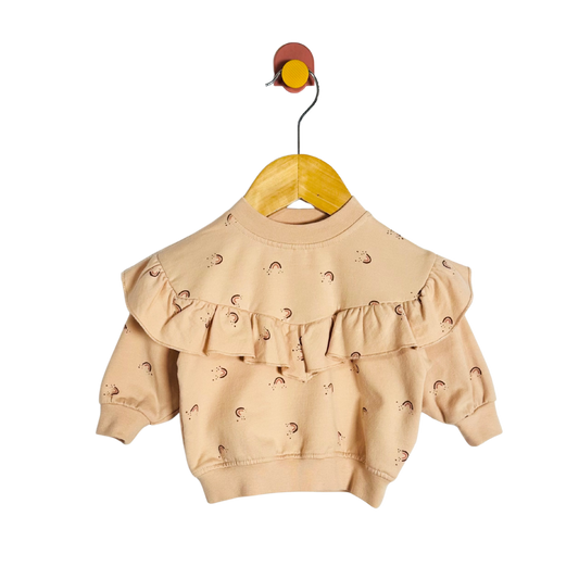 Beige baby sweater with ruffled details on a yellow hanger against a white background
