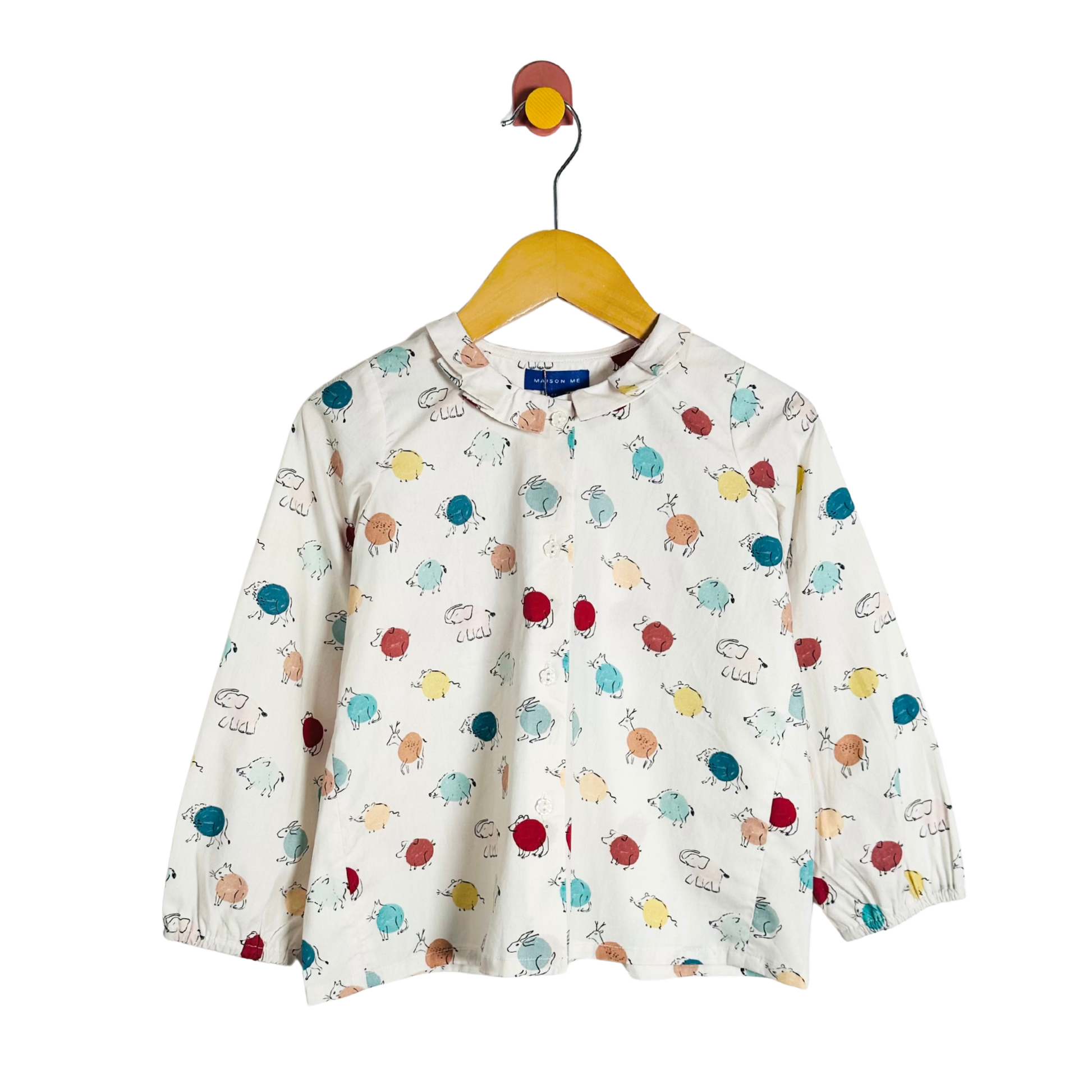 Children's long-sleeve shirt with colorful animal pattern on a hanger against a white background