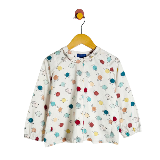Children's long-sleeve shirt with colorful animal pattern on a hanger against a white background