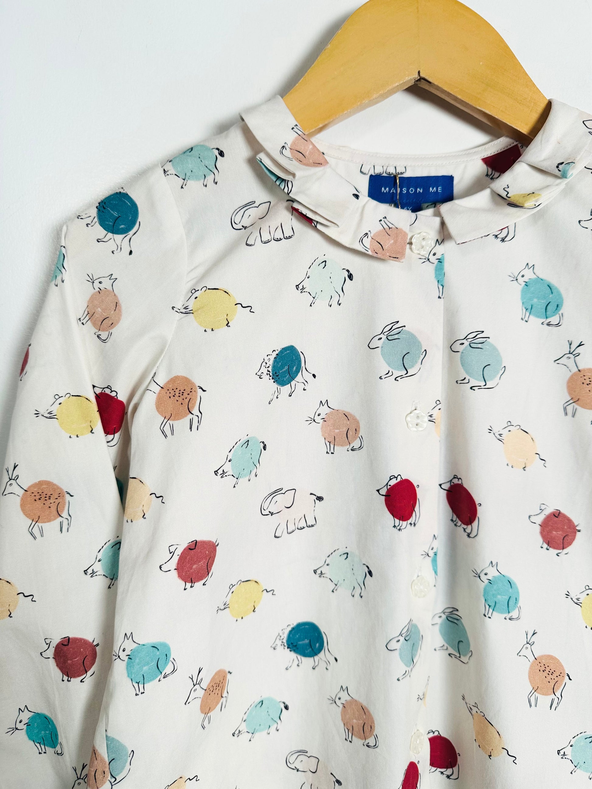 Children's shirt with animal pattern on a hanger
