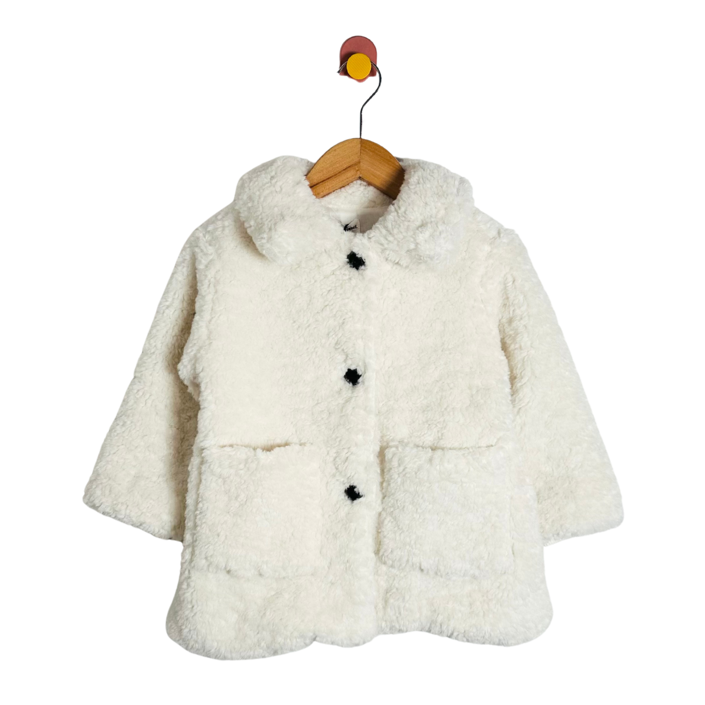 White fluffy coat on a wooden hanger against a white background
