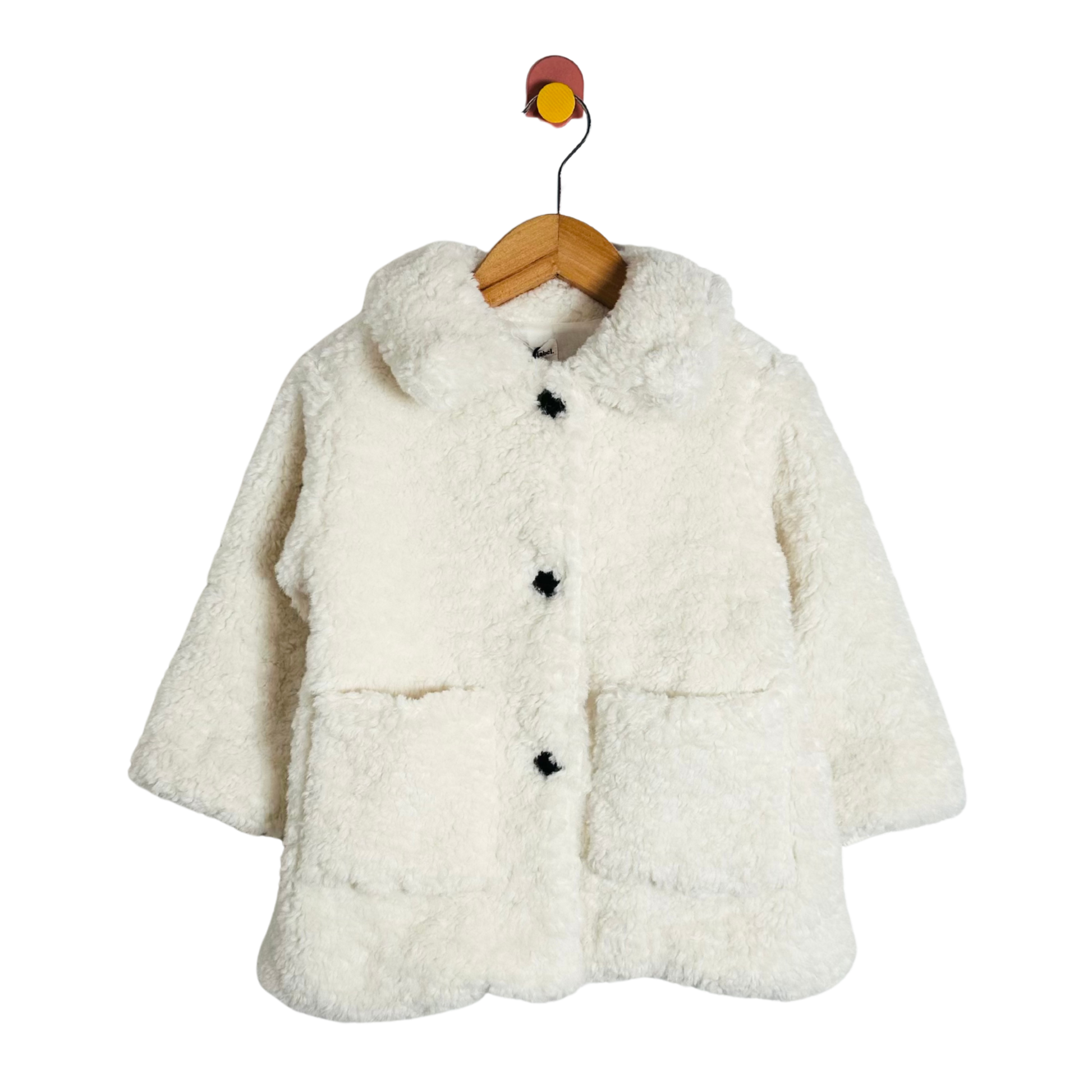 White fluffy coat on a wooden hanger against a white background