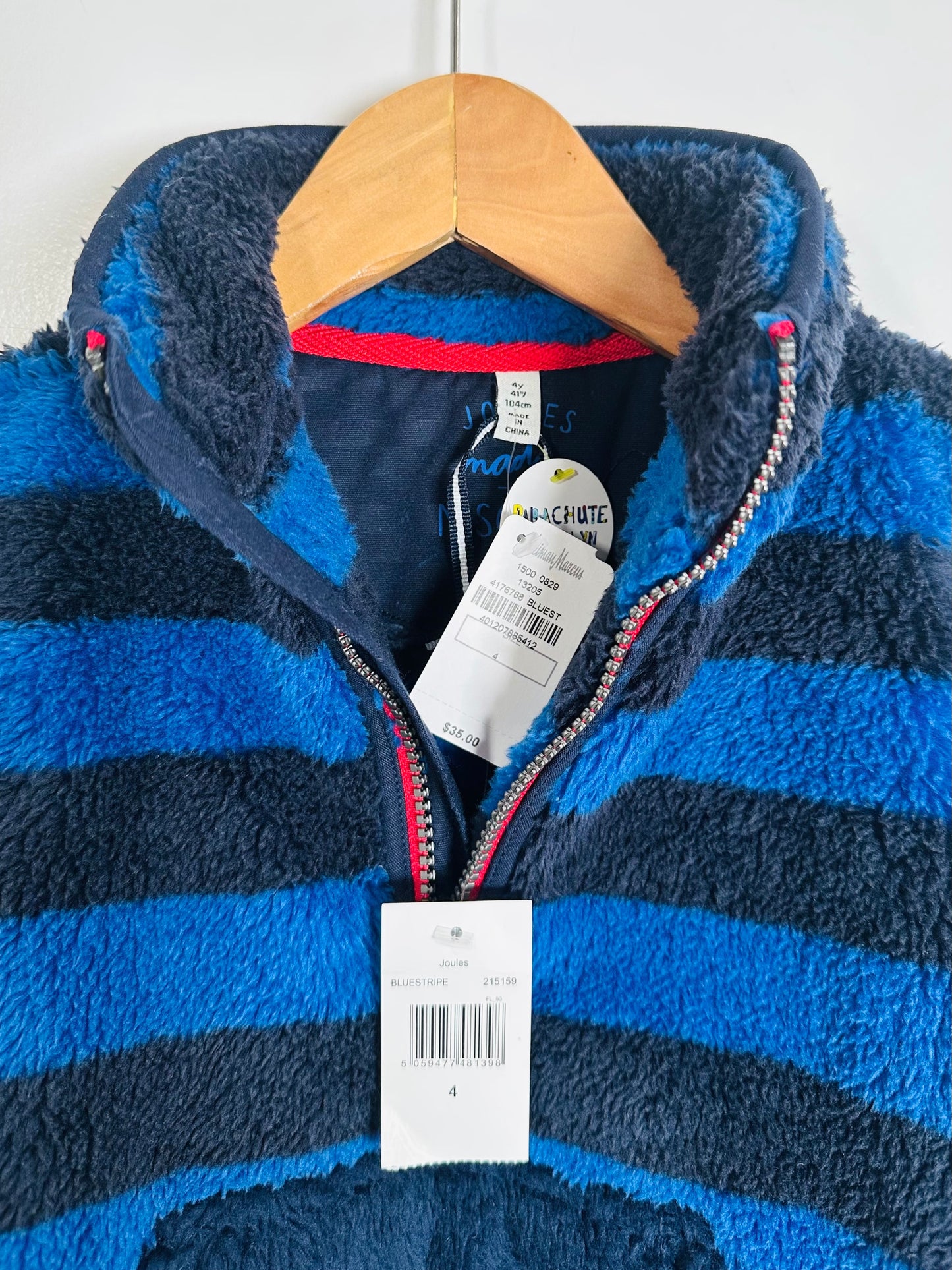 Blue and navy striped fleece jacket on a hanger with a visible brand tag.