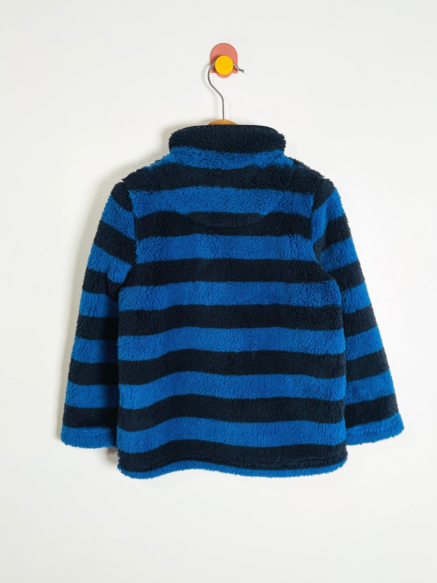 Blue and black striped fleece jacket on a hanger against a white background