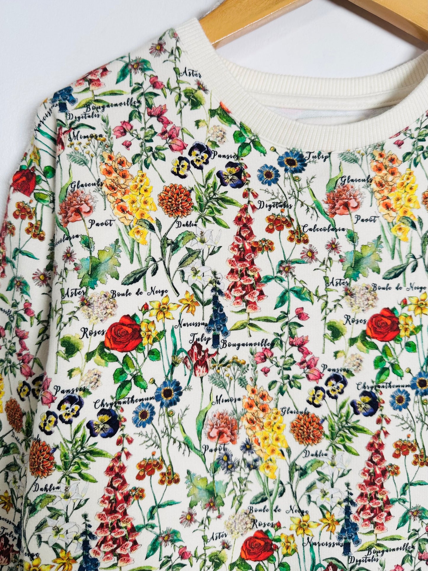 White sweatshirt with colorful floral pattern on a white background