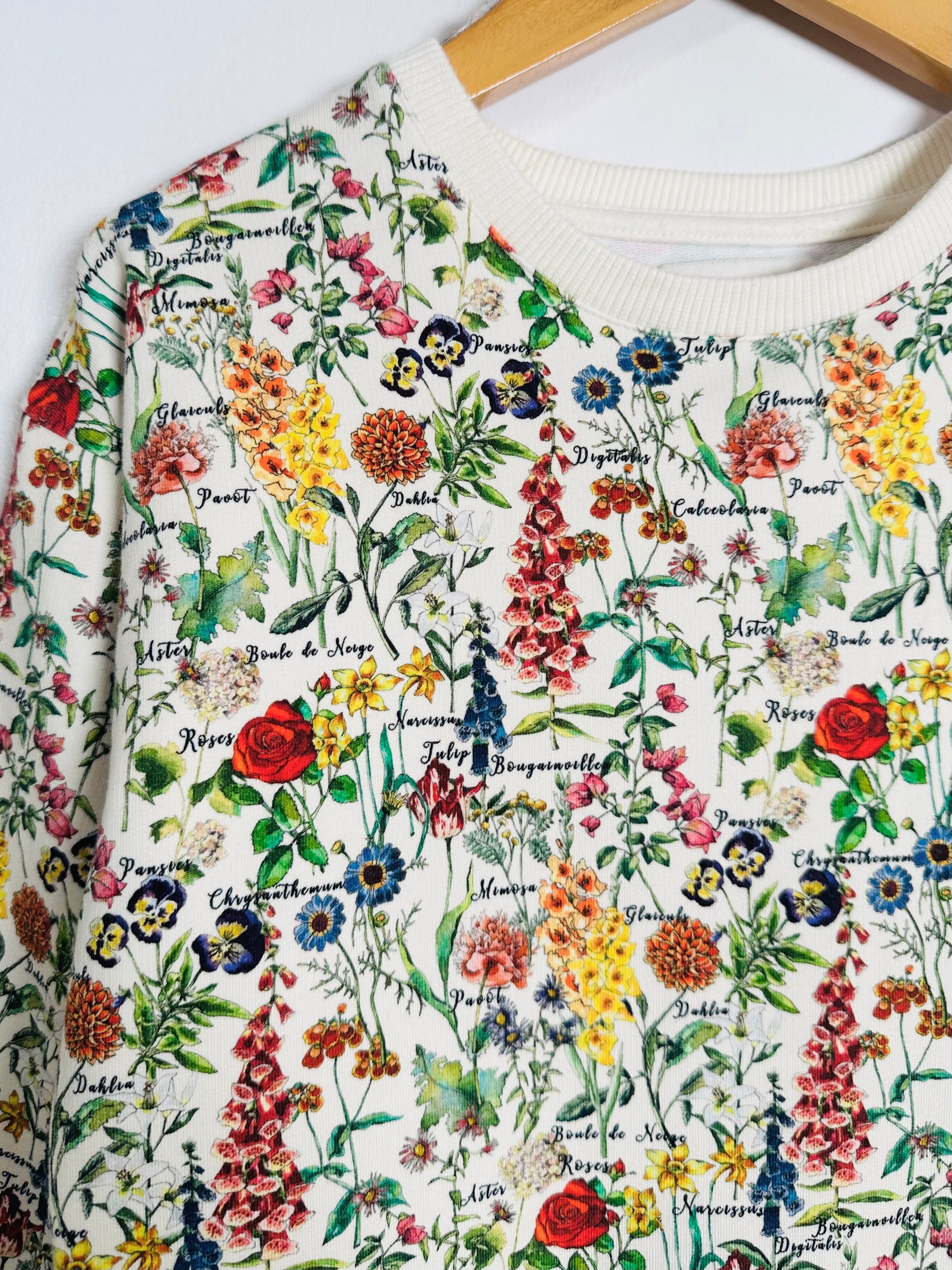 White sweatshirt with colorful floral pattern on a white background
