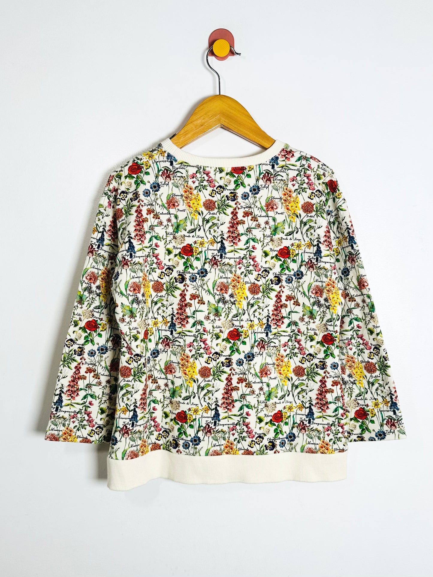 Floral patterned shirt on a hanger against a white background