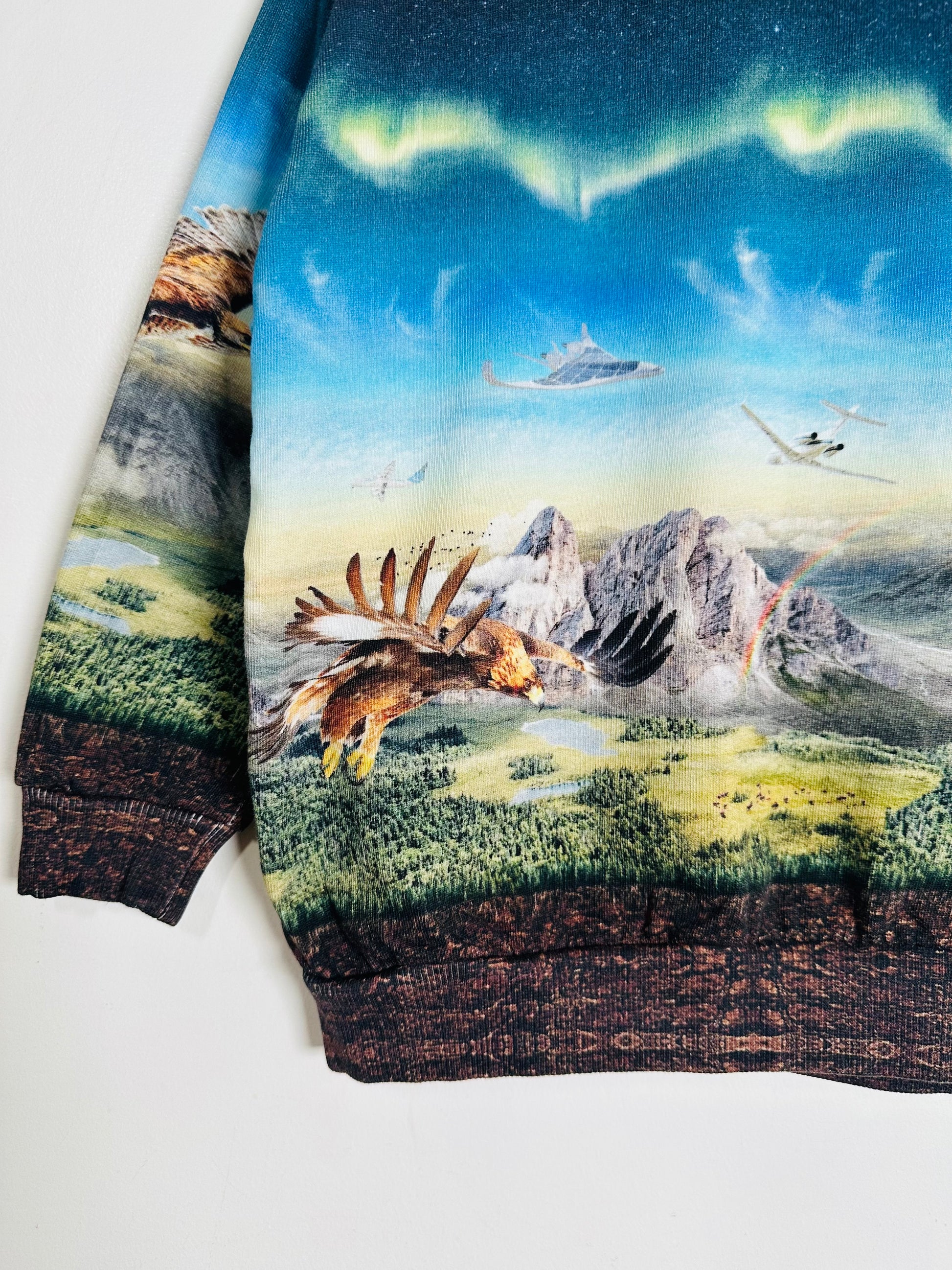 Sweatshirt with a nature-themed design featuring an eagle, mountains, and a helicopter.