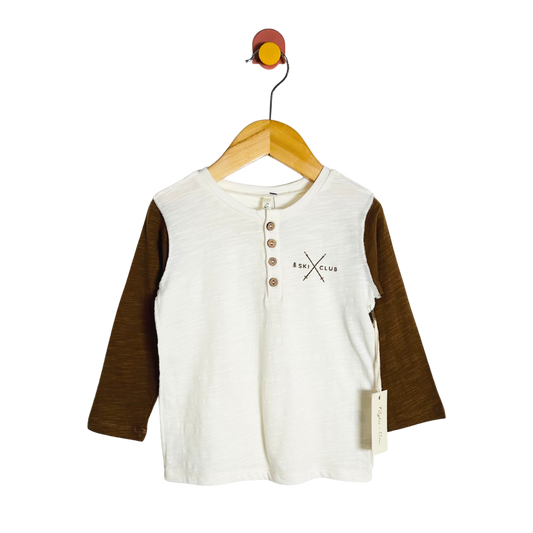 Children's shirt with brown sleeves on a hanger against a white background