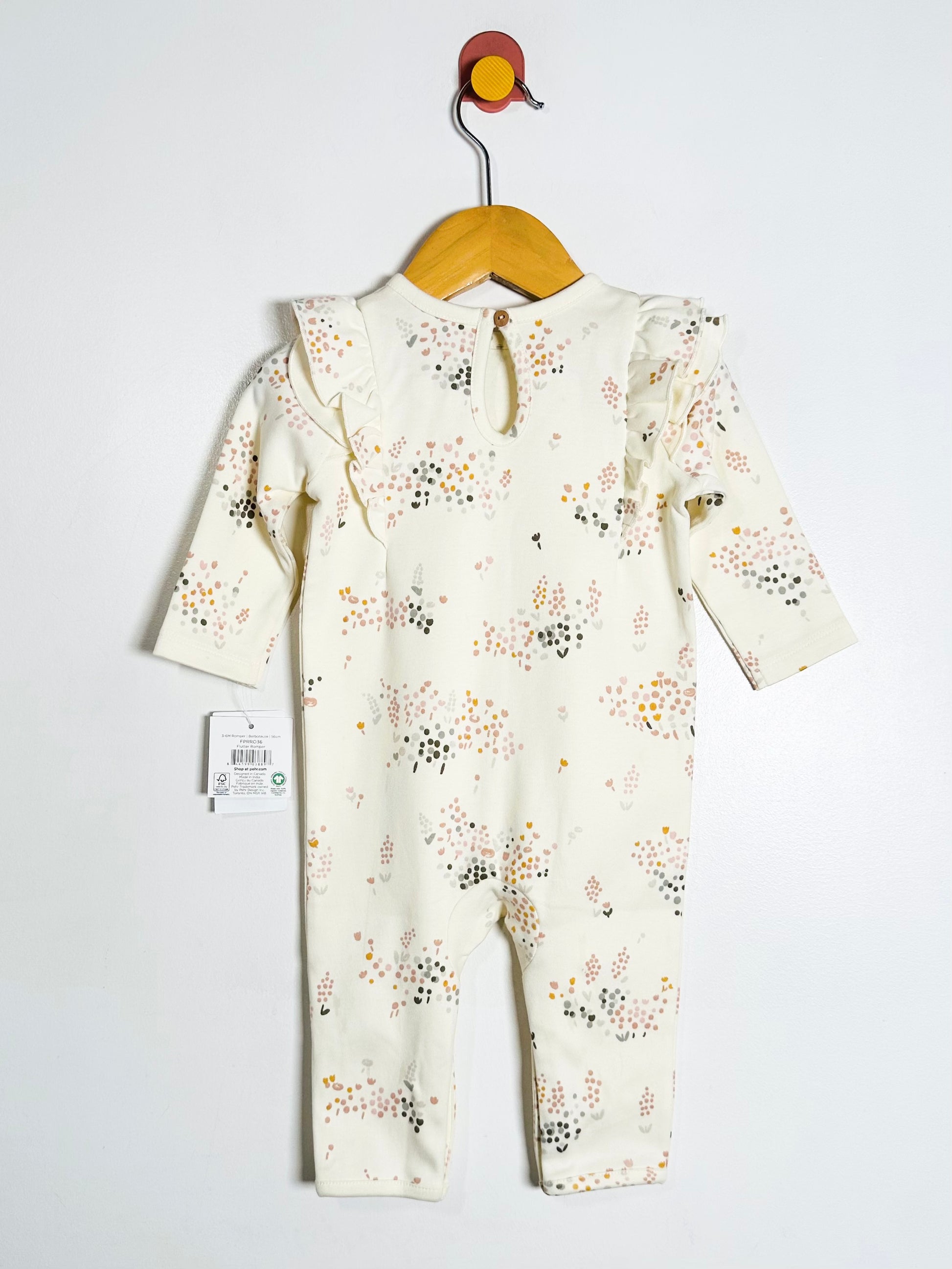 Baby romper with floral pattern on a hanger against a white background