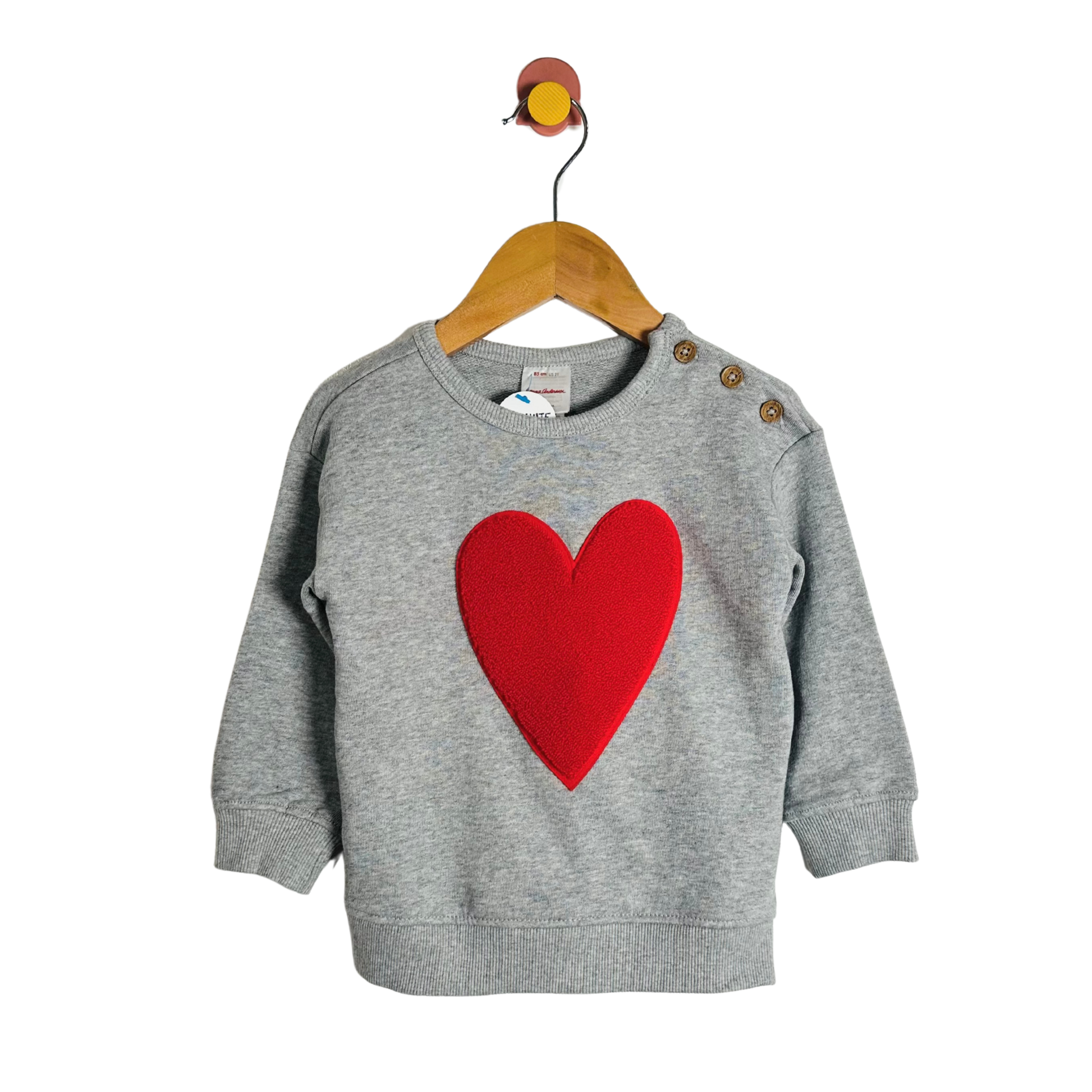 Gray sweater with a red heart on a hanger against a white background