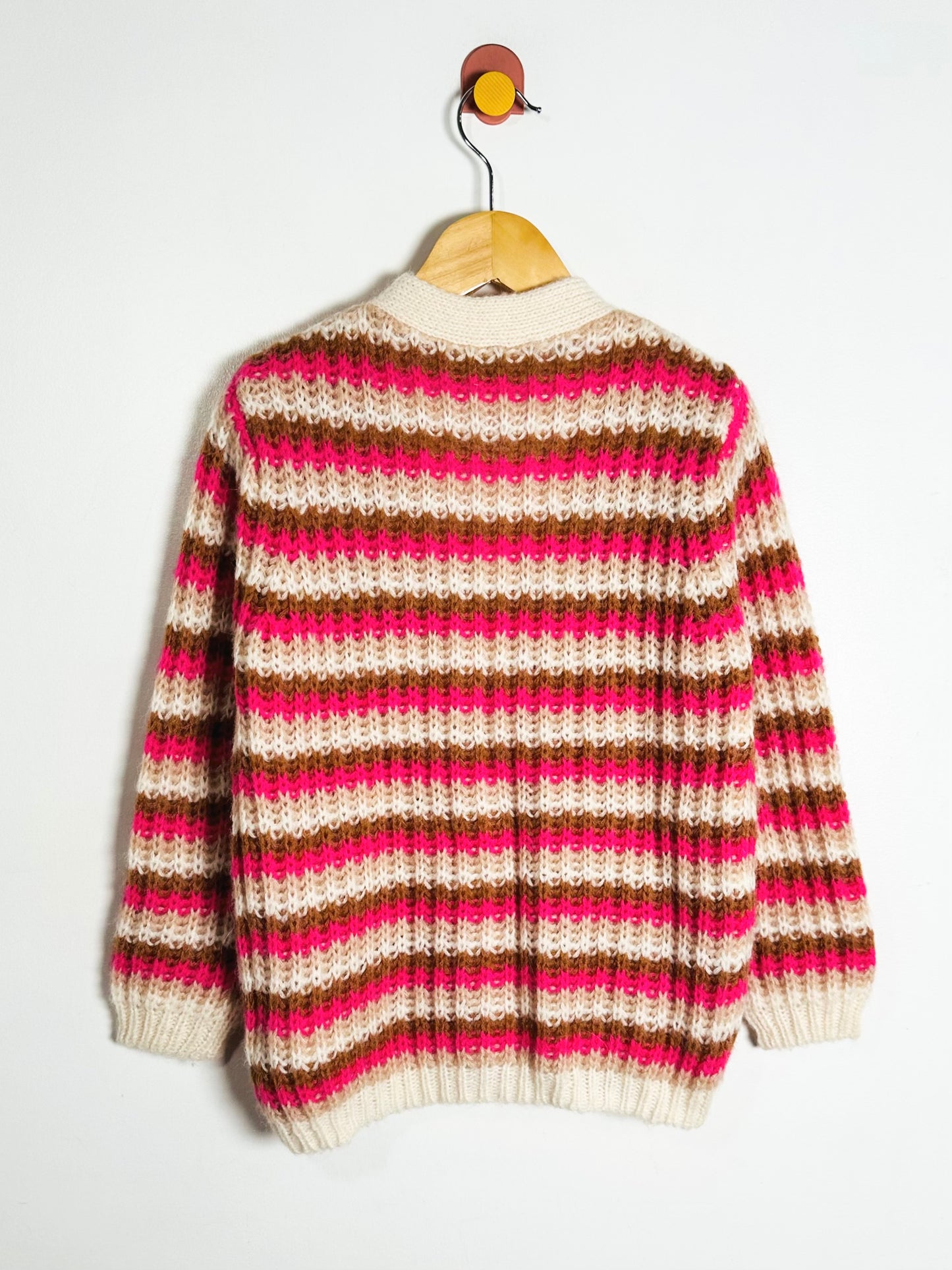 Striped sweater on a hanger against a white background