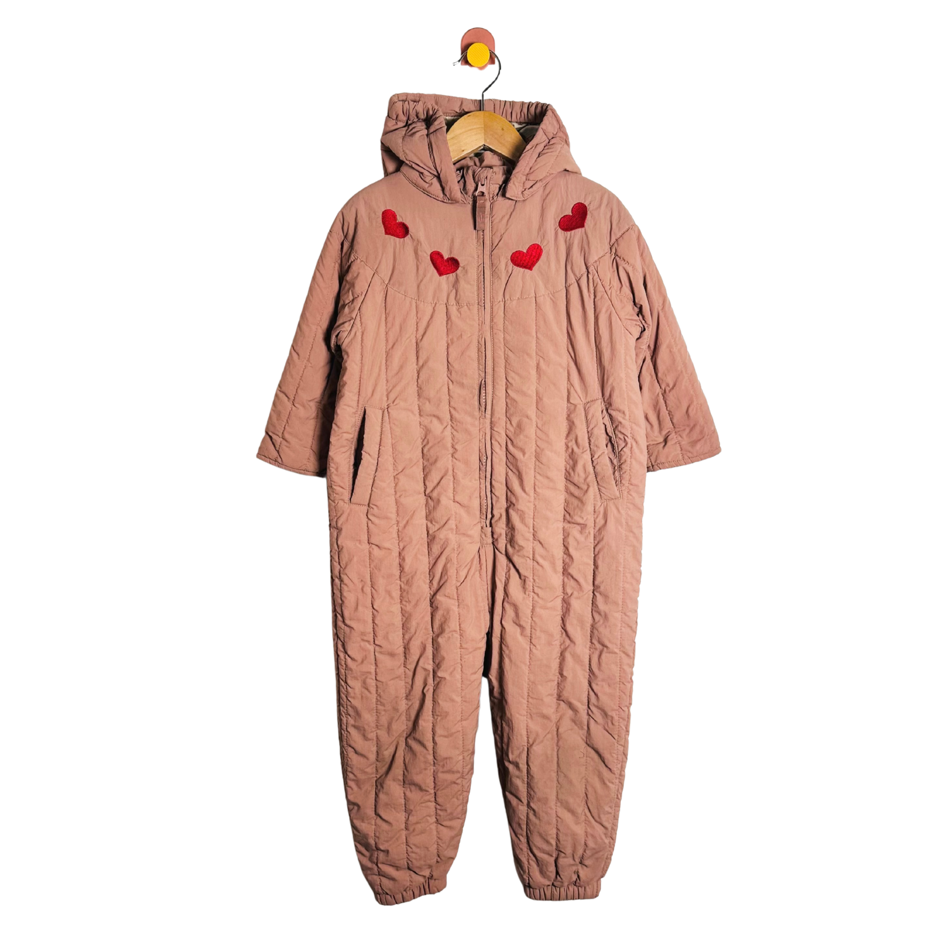 Quilted pink snowsuit with red heart patterns on a white background