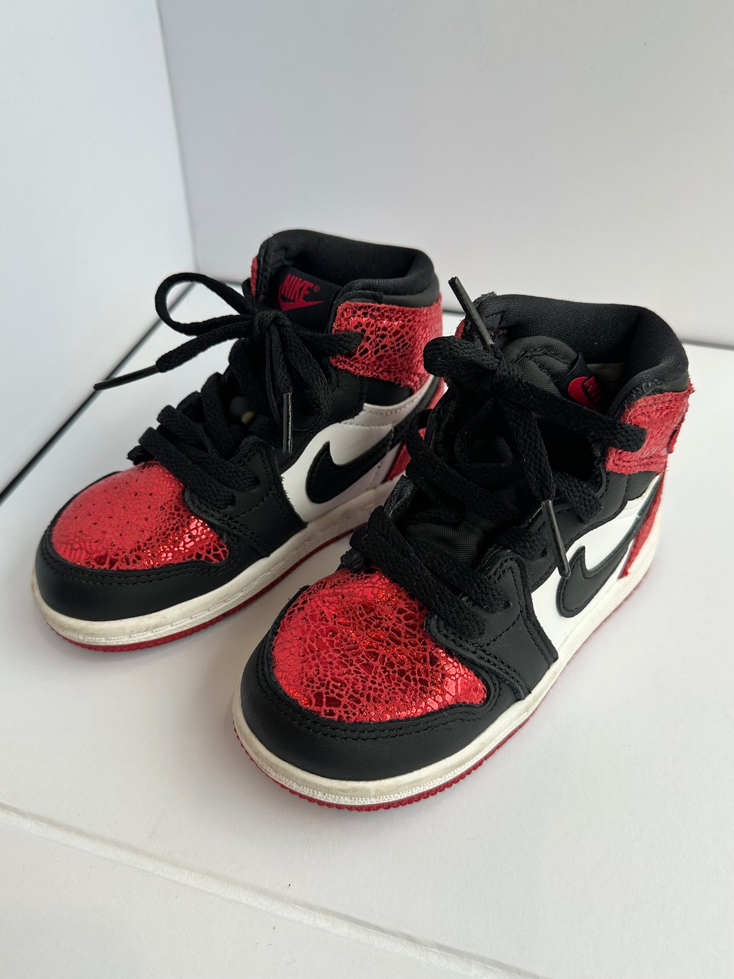 Black and red high-top sneakers with a prominent Nike logo on a white background