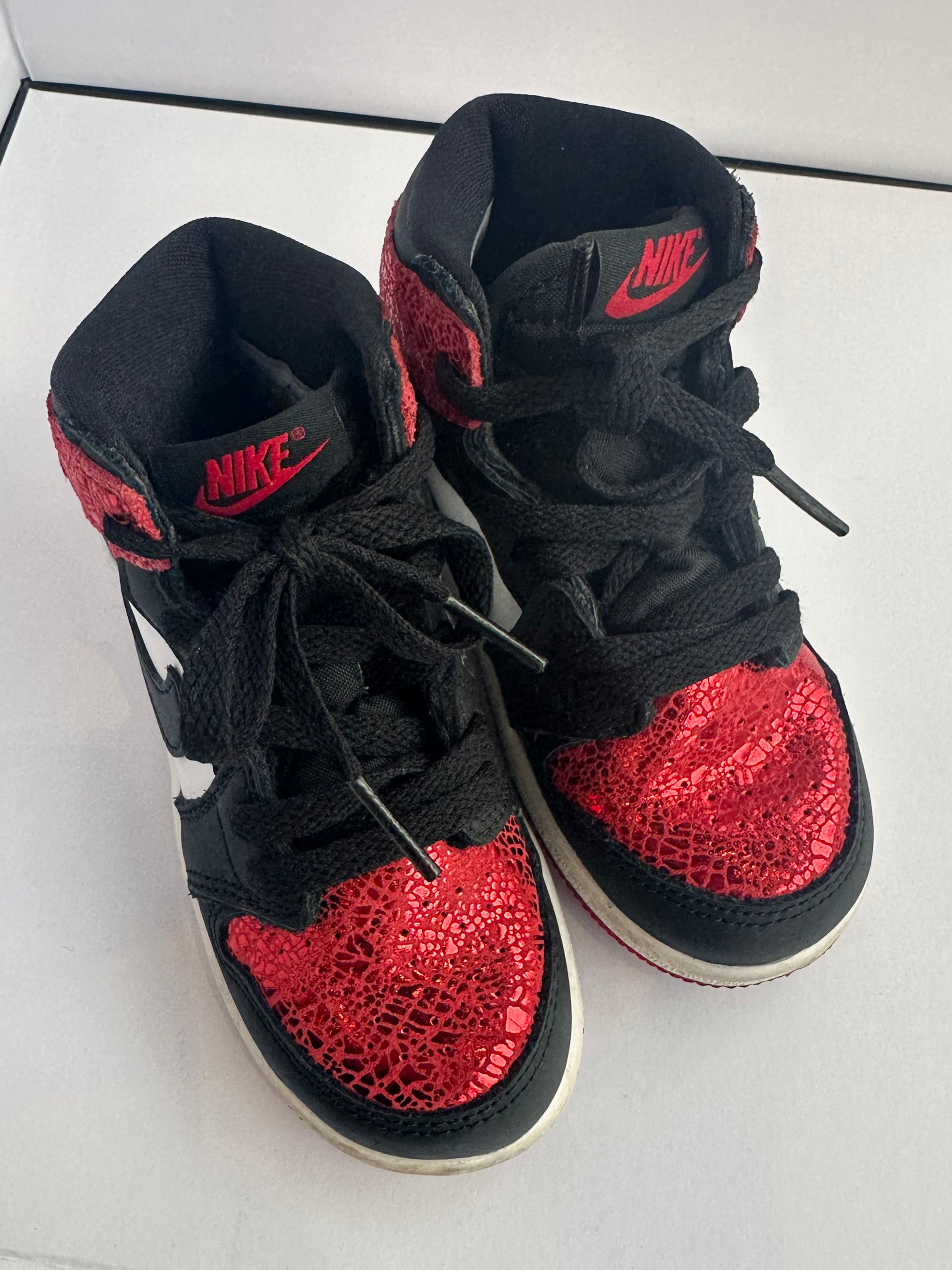 Black and red high-top sneakers with Nike logo on a white background