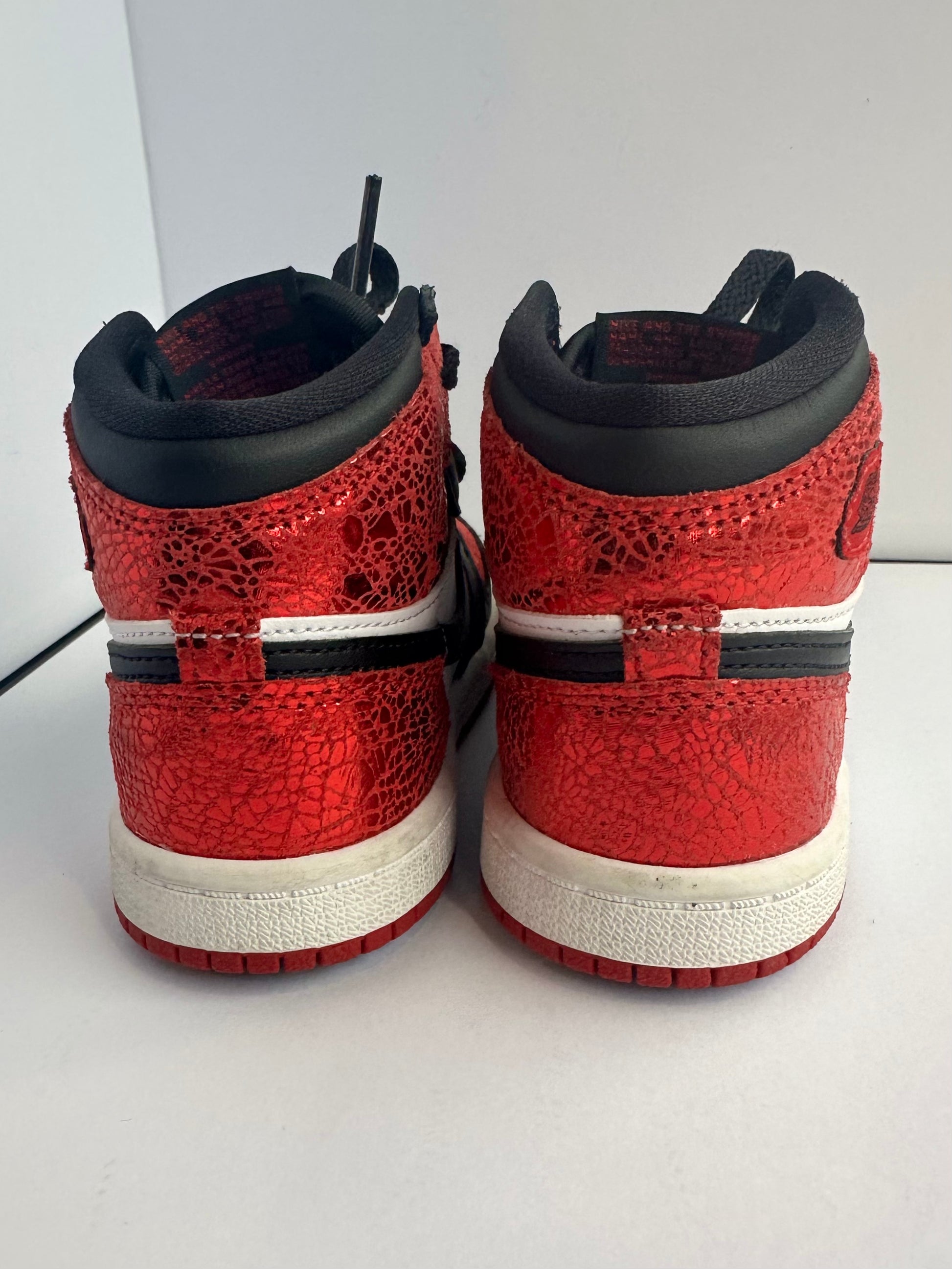 Red and black sneakers with white soles on a light gray background