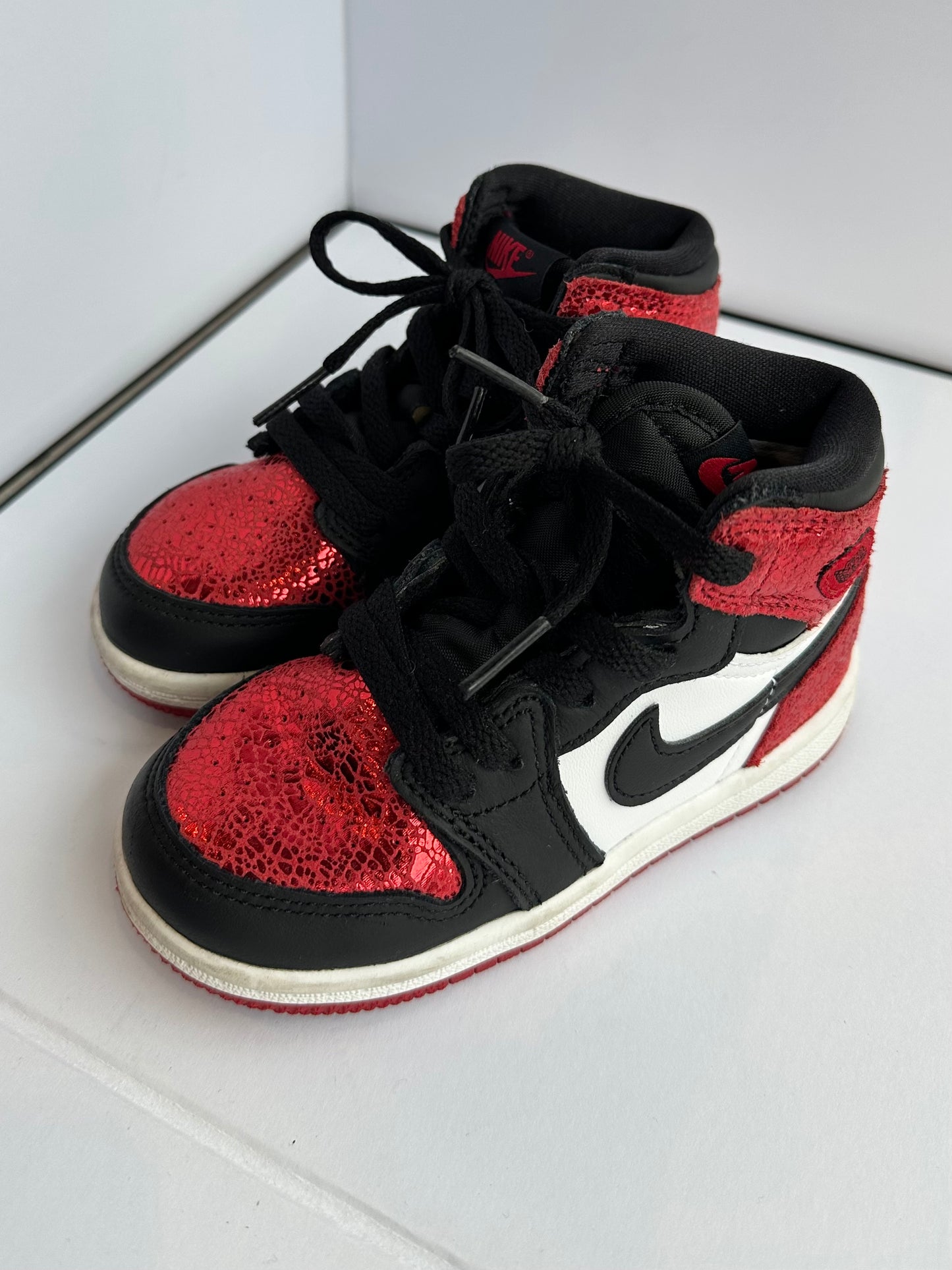 Black and red high-top sneakers with a heart design on a white surface