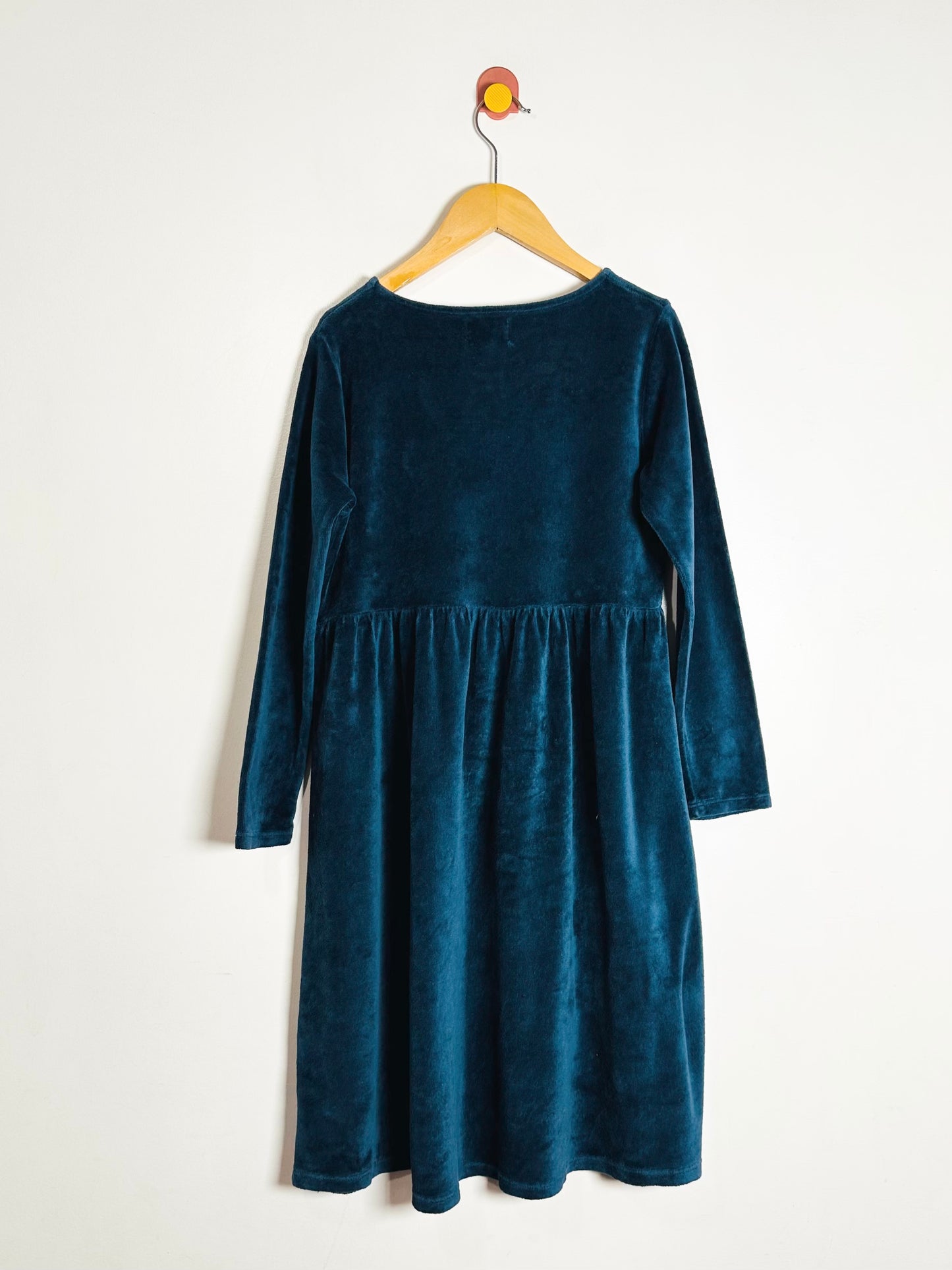 Blue dress on a hanger against a white background