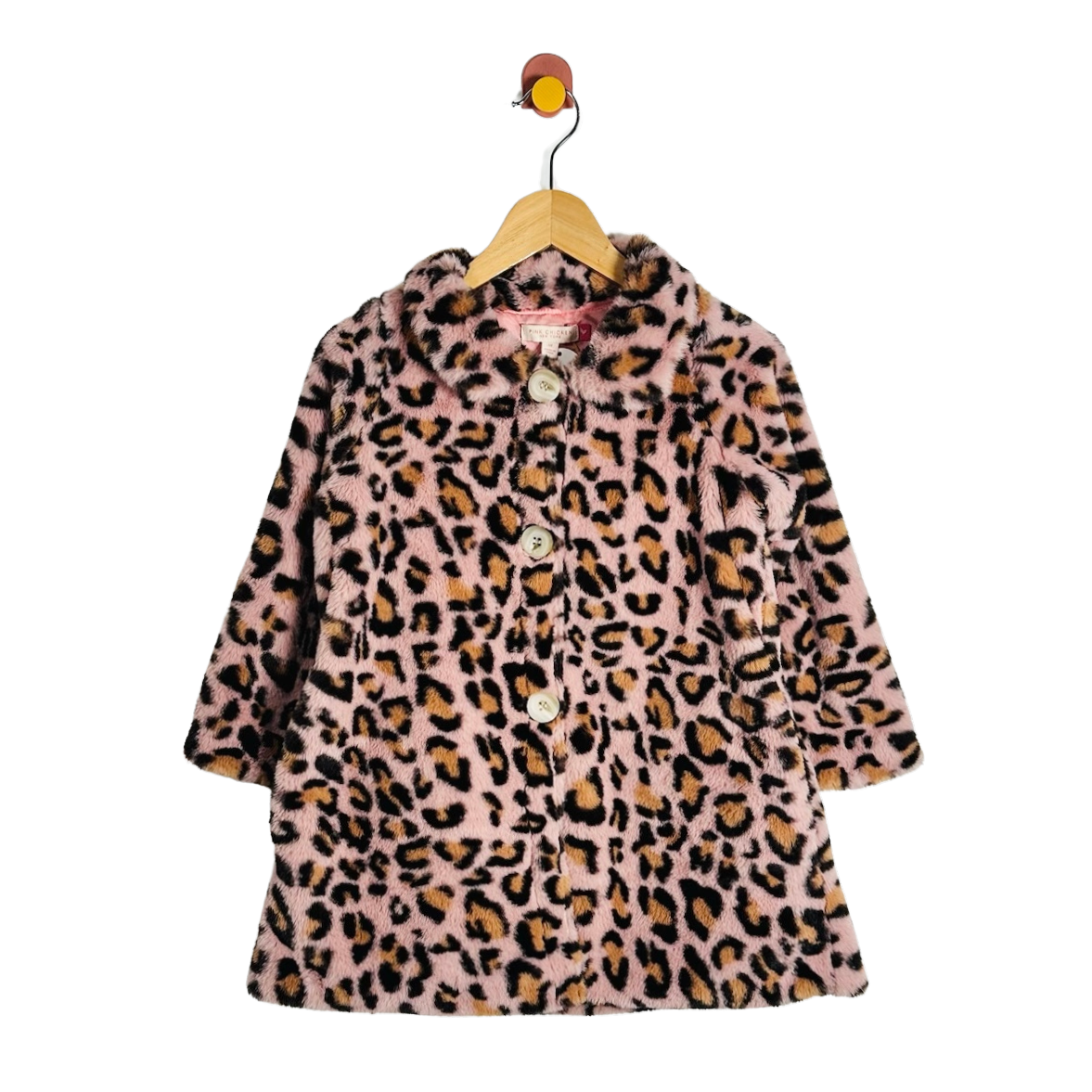 A pink faux fur coat with a leopard print pattern, hanging on a wooden hanger against a white background.