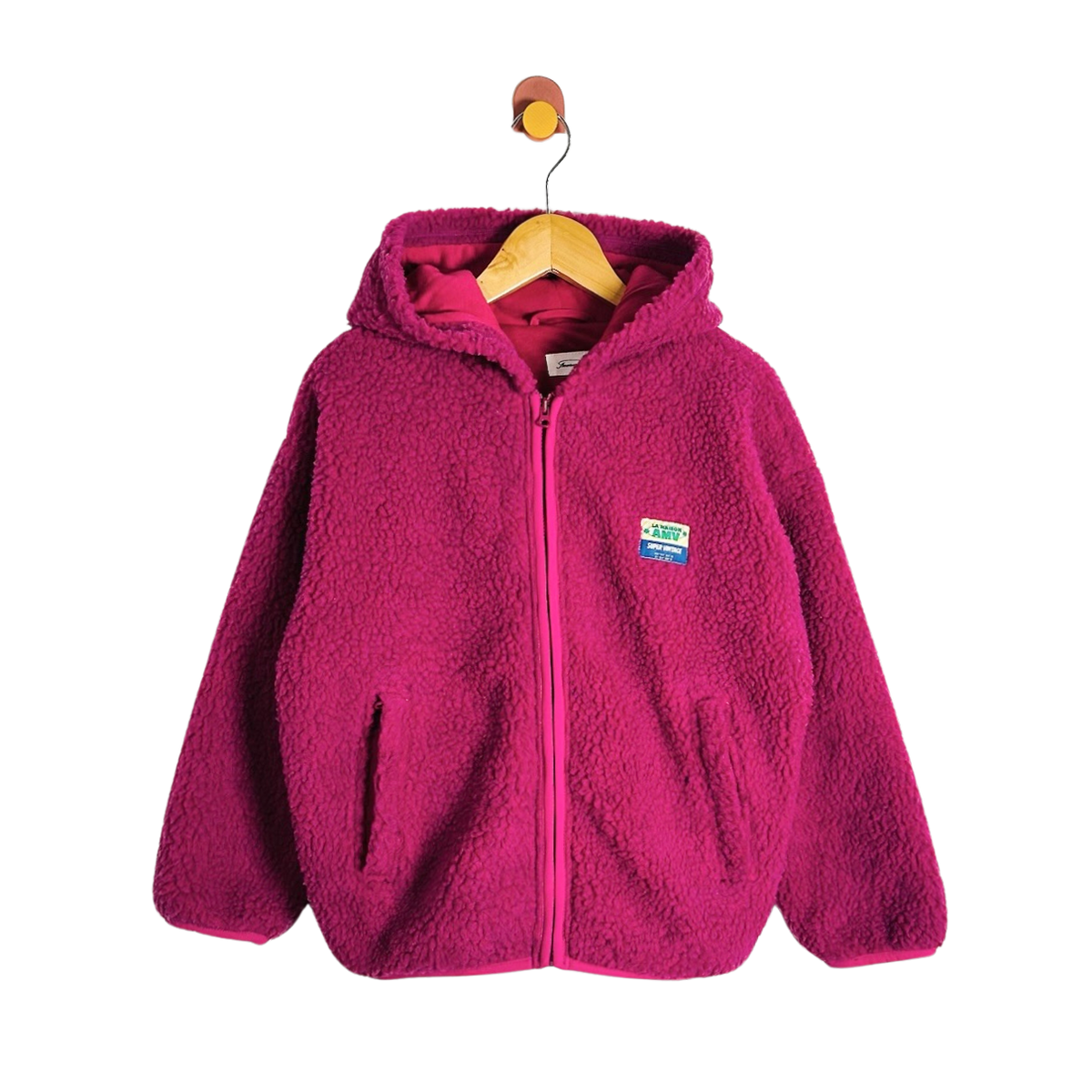 A bright pink fleece zip-up hoodie with a hood and front pockets, hanging on a wooden hanger against a plain white background.