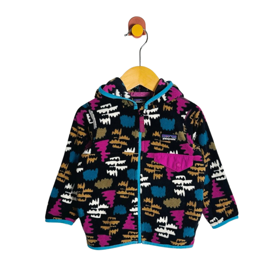 A children's hooded zip-up fleece jacket with a colorful abstract pattern, hanging on a wooden hanger against a plain white background.