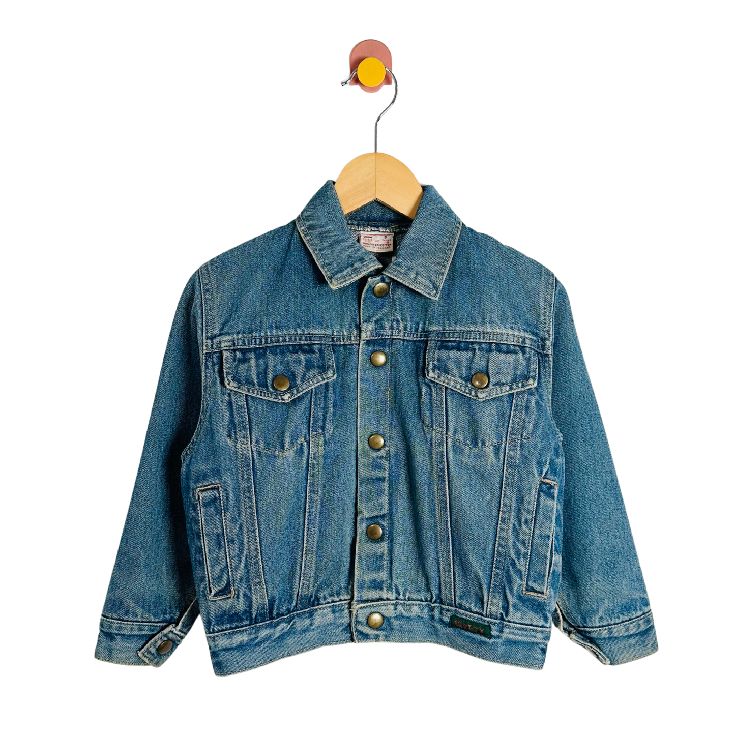Blue denim jacket on a wooden hanger against a white background