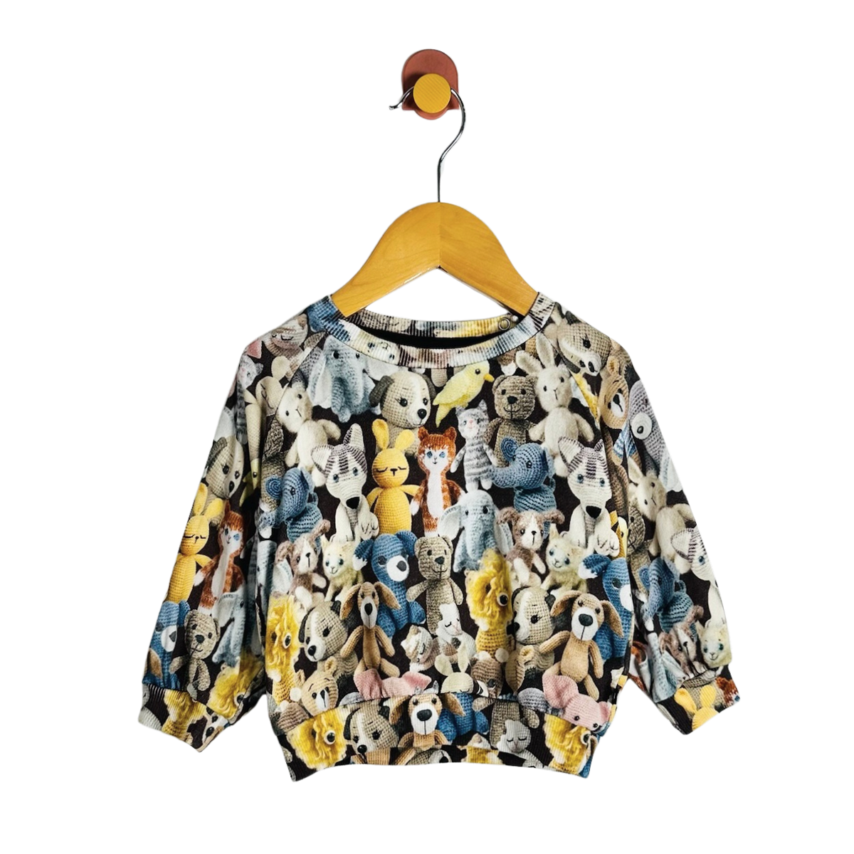 A long-sleeve crewneck sweatshirt for toddlers, featuring an all-over colorful print of teddy bears, dogs, cats, and other cartoon animals. The sweatshirt is displayed on a wooden hanger against a solid white background.