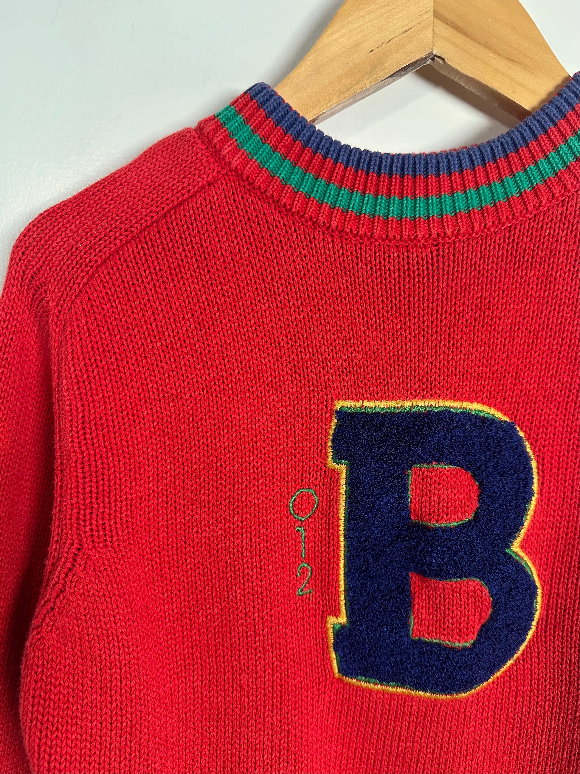 Red sweater with a large blue 'B' on a hanger