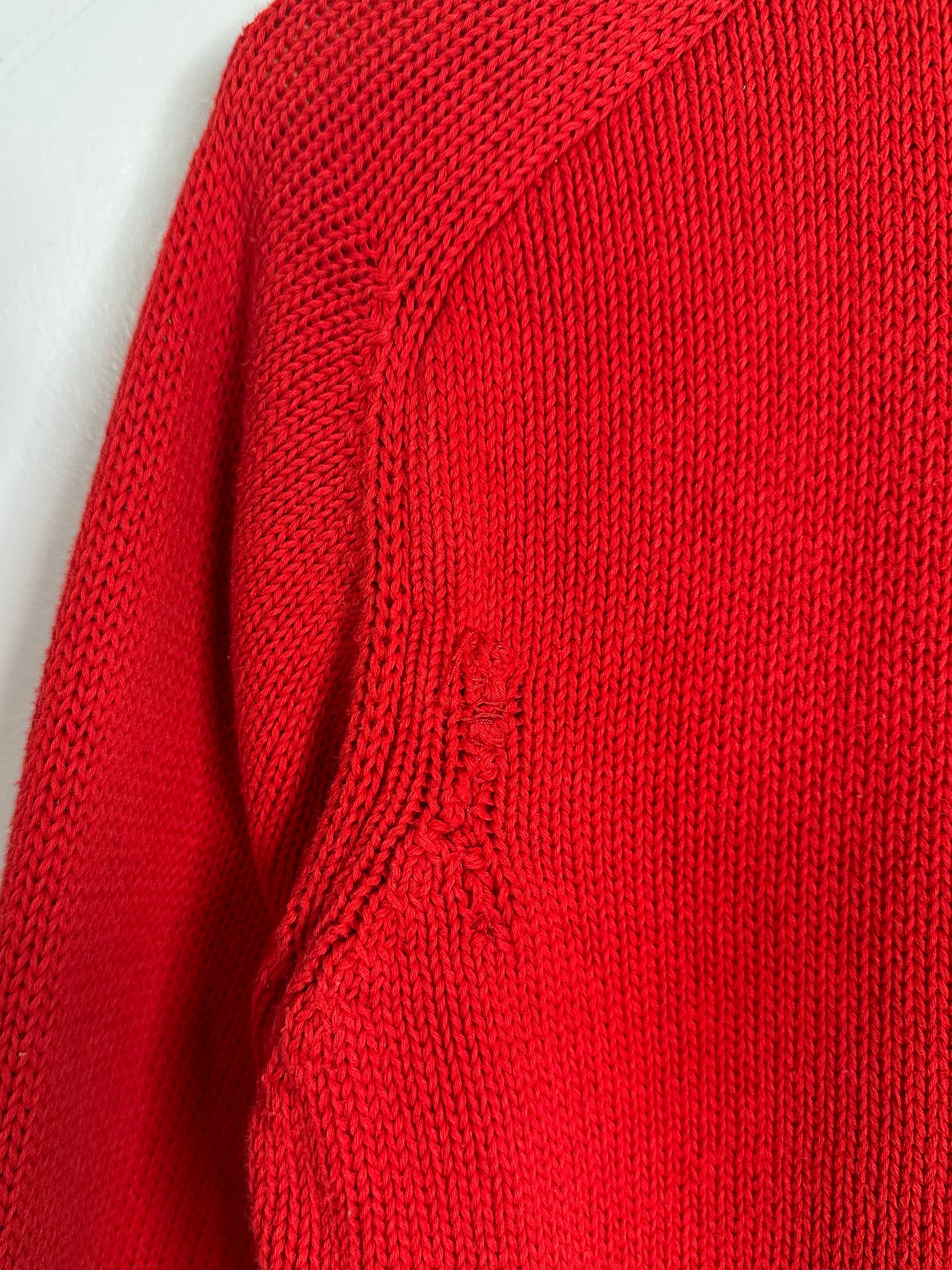 Close-up of a red knitted sweater on a light gray background