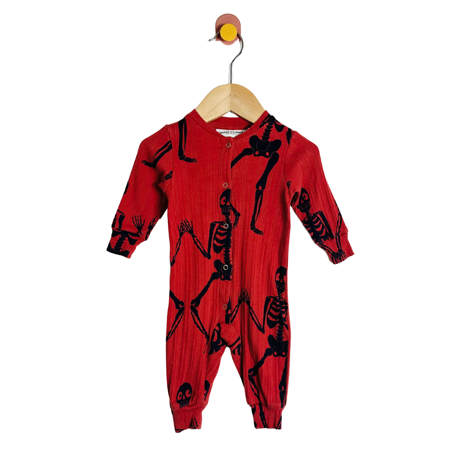 Red baby onesie with black skeleton patterns on a hanger against a white background