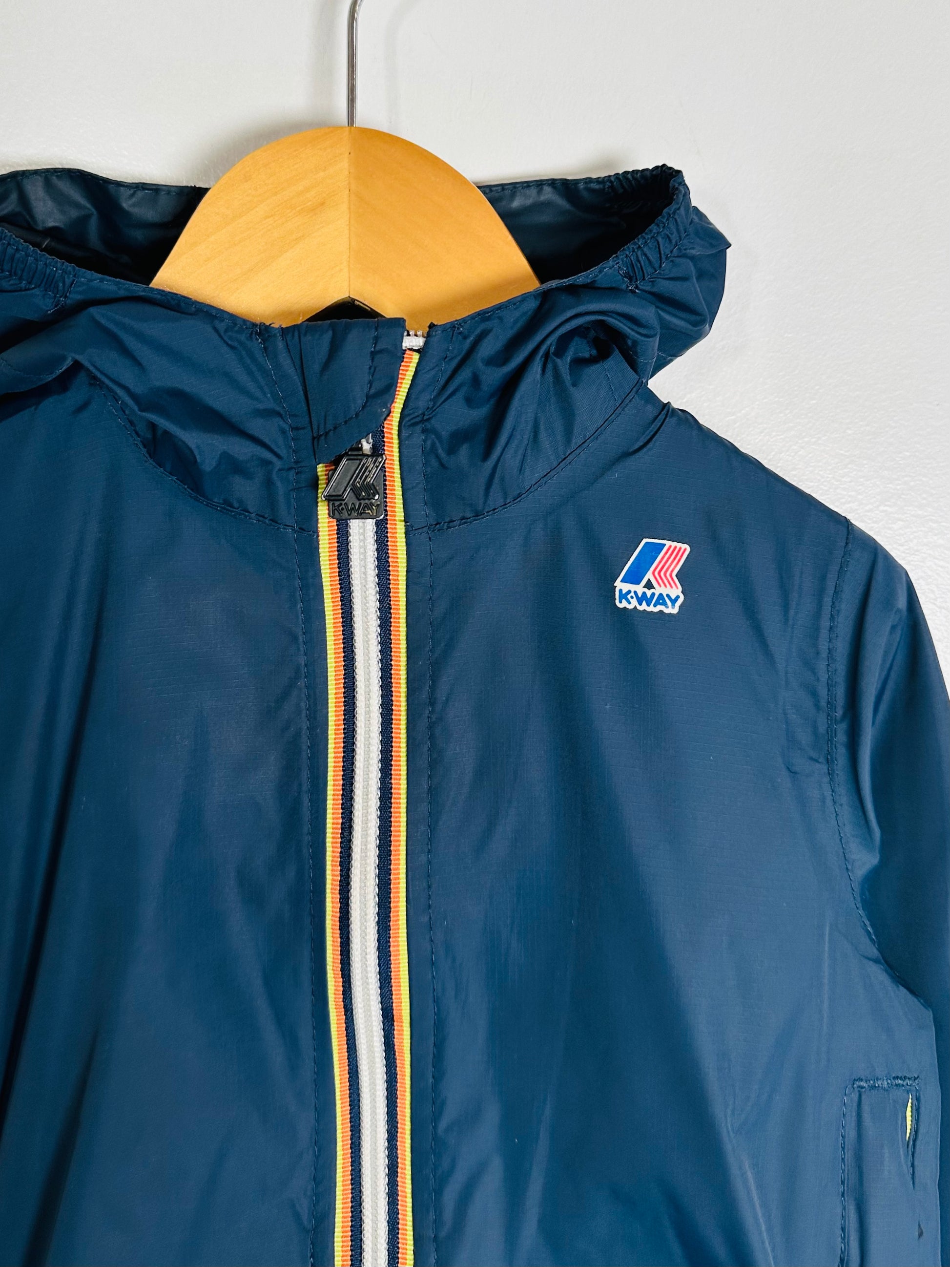 Blue jacket with a brand logo on a hanger against a white background