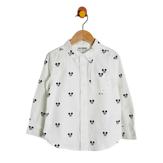 White shirt with black mickey mouse head pattern on a hanger against a white background