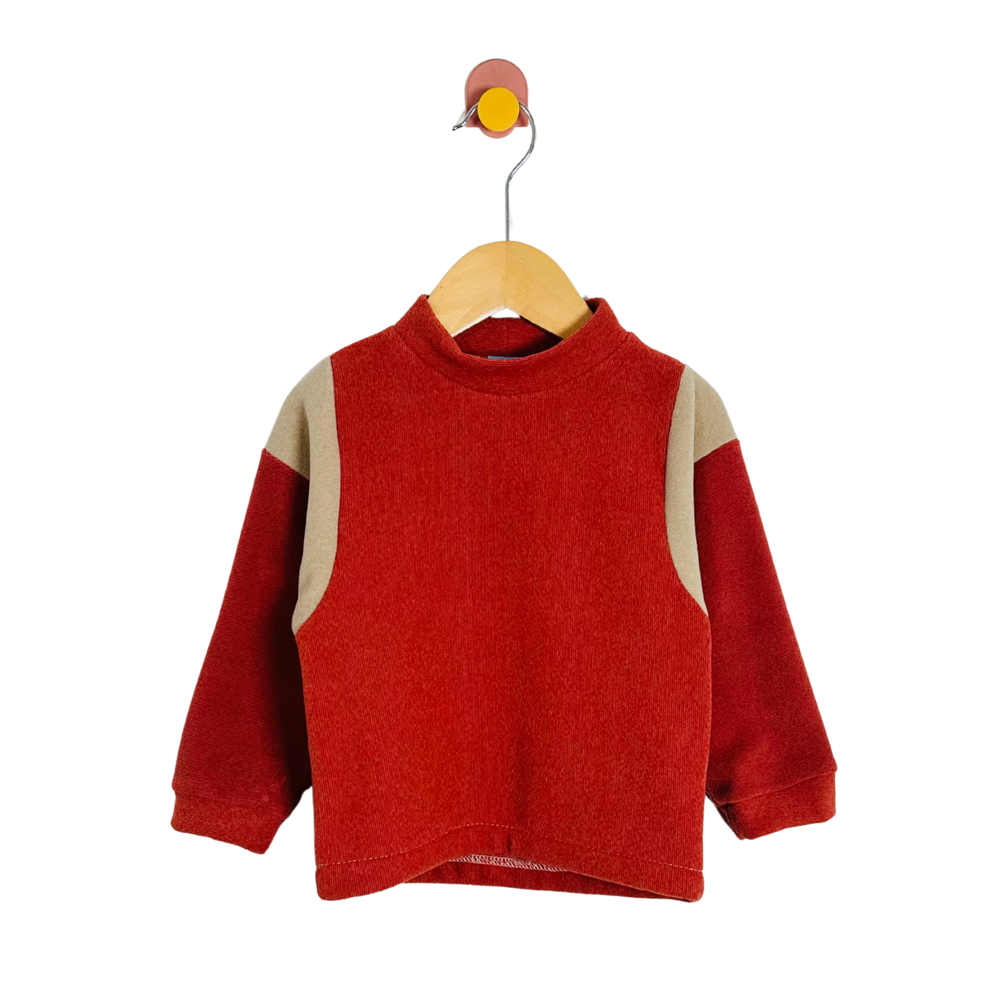 Red sweater with beige accents on a wooden hanger against a white background