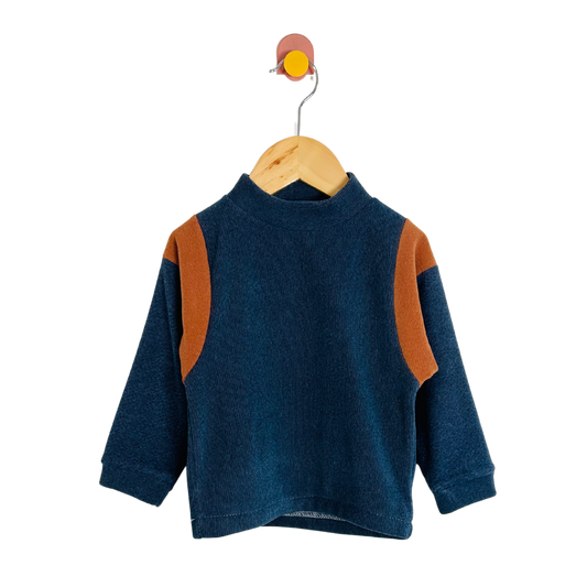 Blue sweater with brown accents on a wooden hanger against a white background