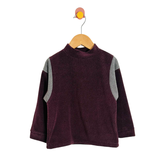 Children's purple sweater with gray sleeves on a wooden hanger against a white background