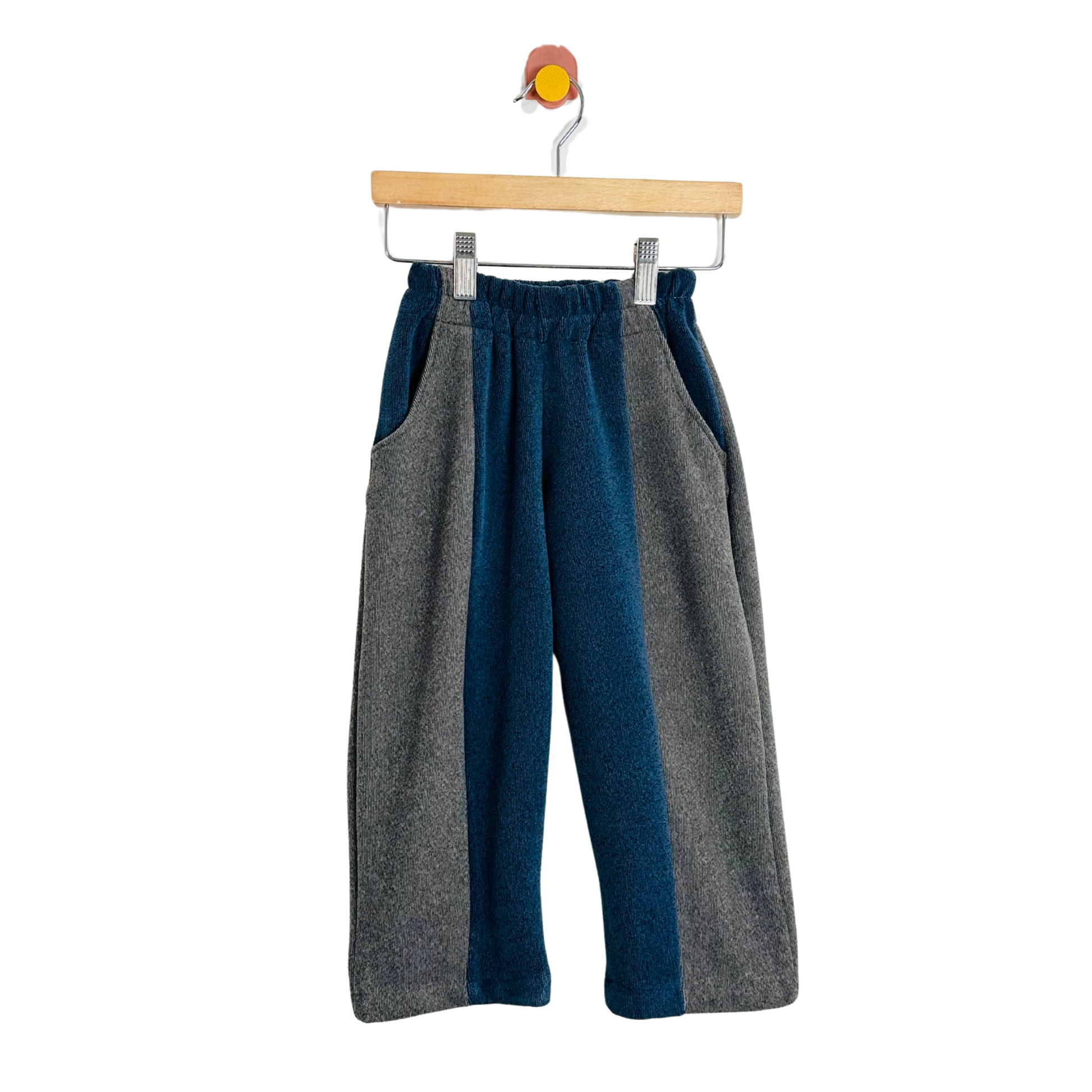 Two-tone gray and blue pants on a hanger against a white background