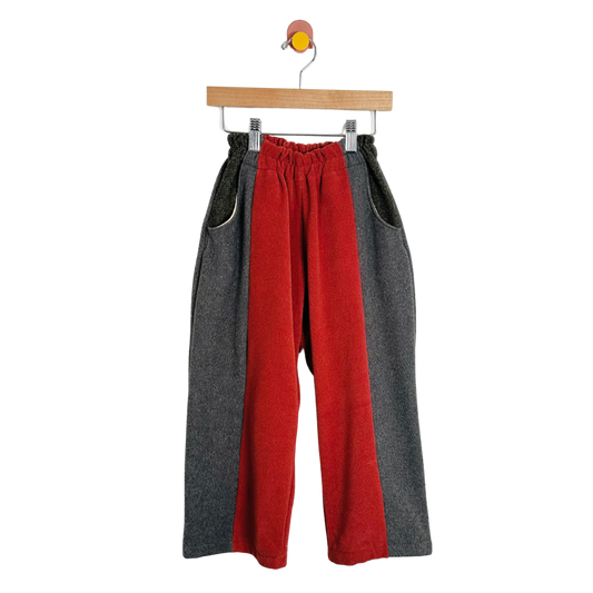Red and gray pants on a hanger against a white background
